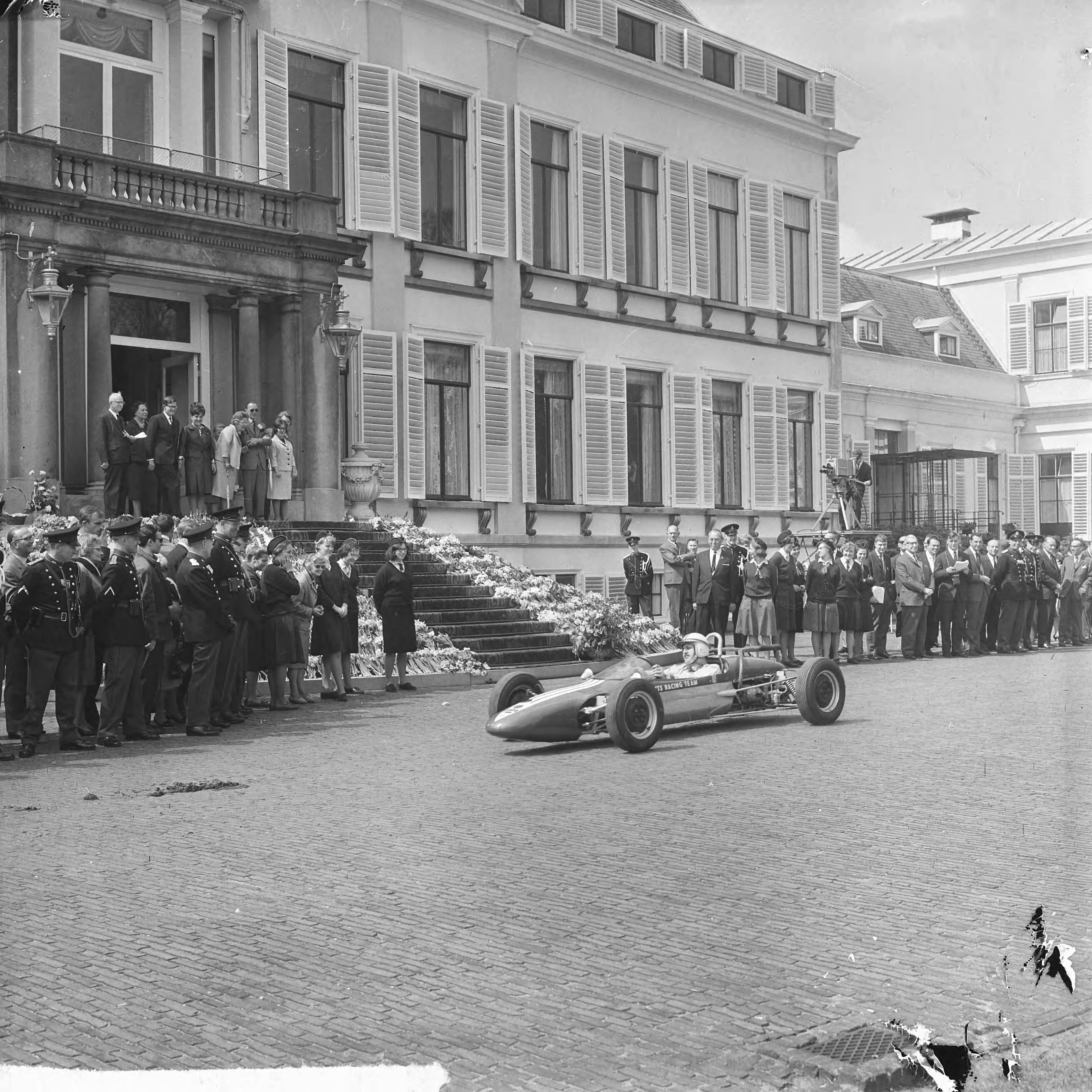 Koninginnedag 1965 — Defilé langs het bordes van raceauto's — Foto: Koch, Eric / Anefo. Licentie: Set B: Rechtenvrij / Publiek Domein. Bron: Nationaal Archief. http://hdl.handle.net/10648/aaa4108e-d0b4-102d-bcf8-003048976d84