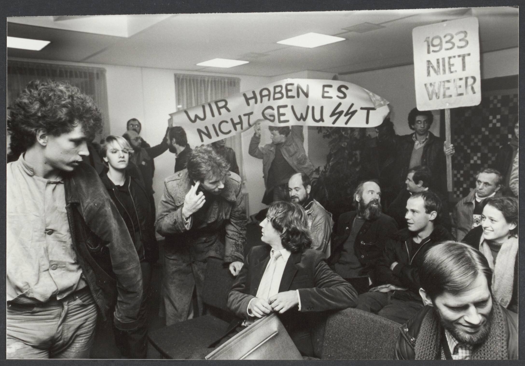 C.P. (Centrum Partij). niet te verwarren met C.P.'86, ook Janmaat bij CP. — In Almere zijn de twee Centrumpartij raadsleden niet zonder problemen geïnstalleerd. Op de publieke tribune werden spandoeken meegevoerd terwijl demonstranten zich met CP-partijiideoloog Vierling (midden) "onderhouden" — Foto: Croes, Rob C. / Anefo (1). Licentie: Set B: Rechtenvrij / Publiek Domein. Bron: Nationaal Archief. http://hdl.handle.net/10648/49be7329-92bc-291c-bcfe-6481399a713b