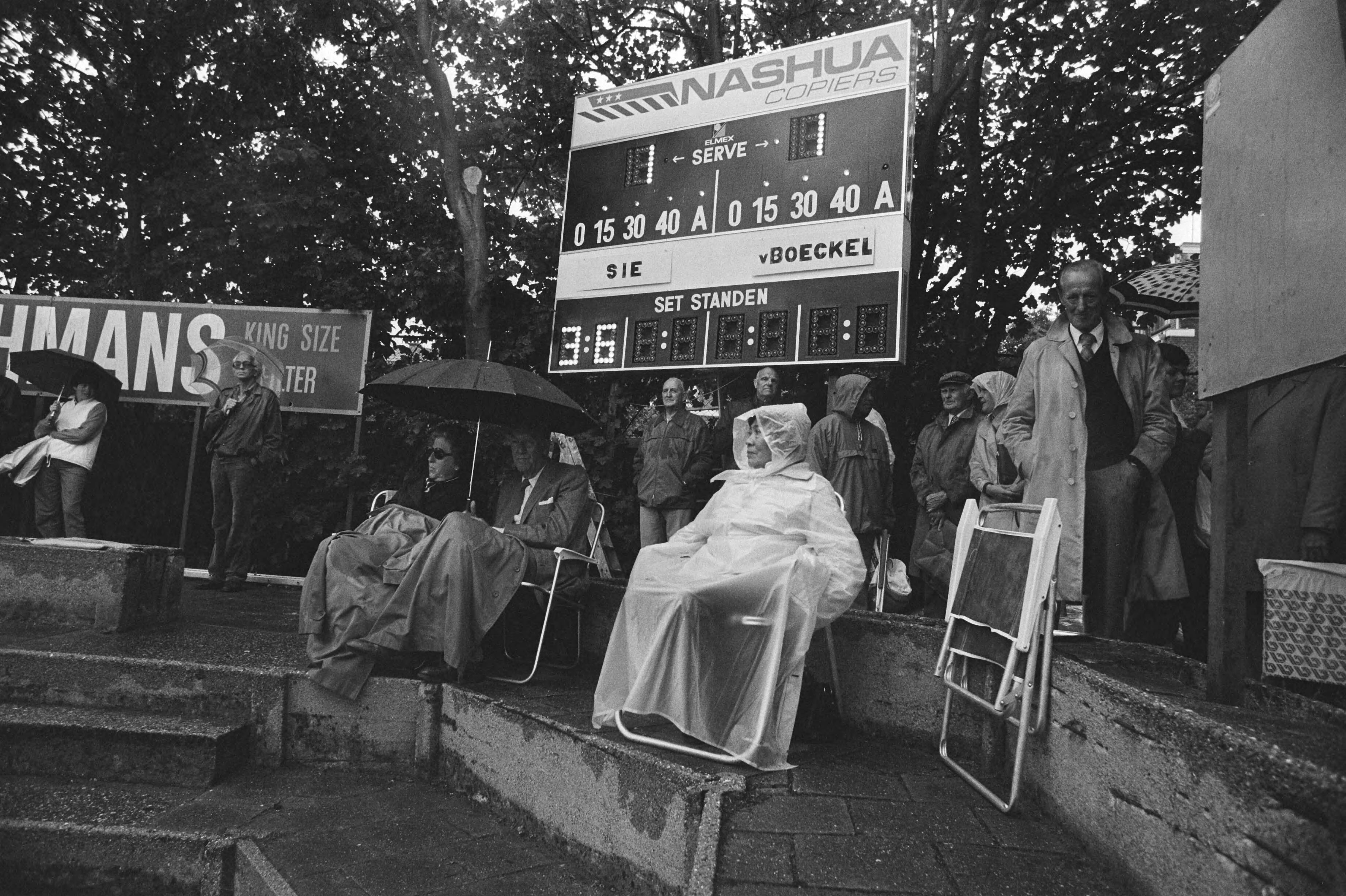 Fotocollectie Anefo — Nationale tenniskampioenschappen, Scheveningen; dweilen op verregende tennisbanen (METS) — Foto: Croes, Rob C. / Anefo. Licentie: Set B: Rechtenvrij / Publiek Domein. Bron: Nationaal Archief. http://hdl.handle.net/10648/ad1c95b6-d0b4-102d-bcf8-003048976d84