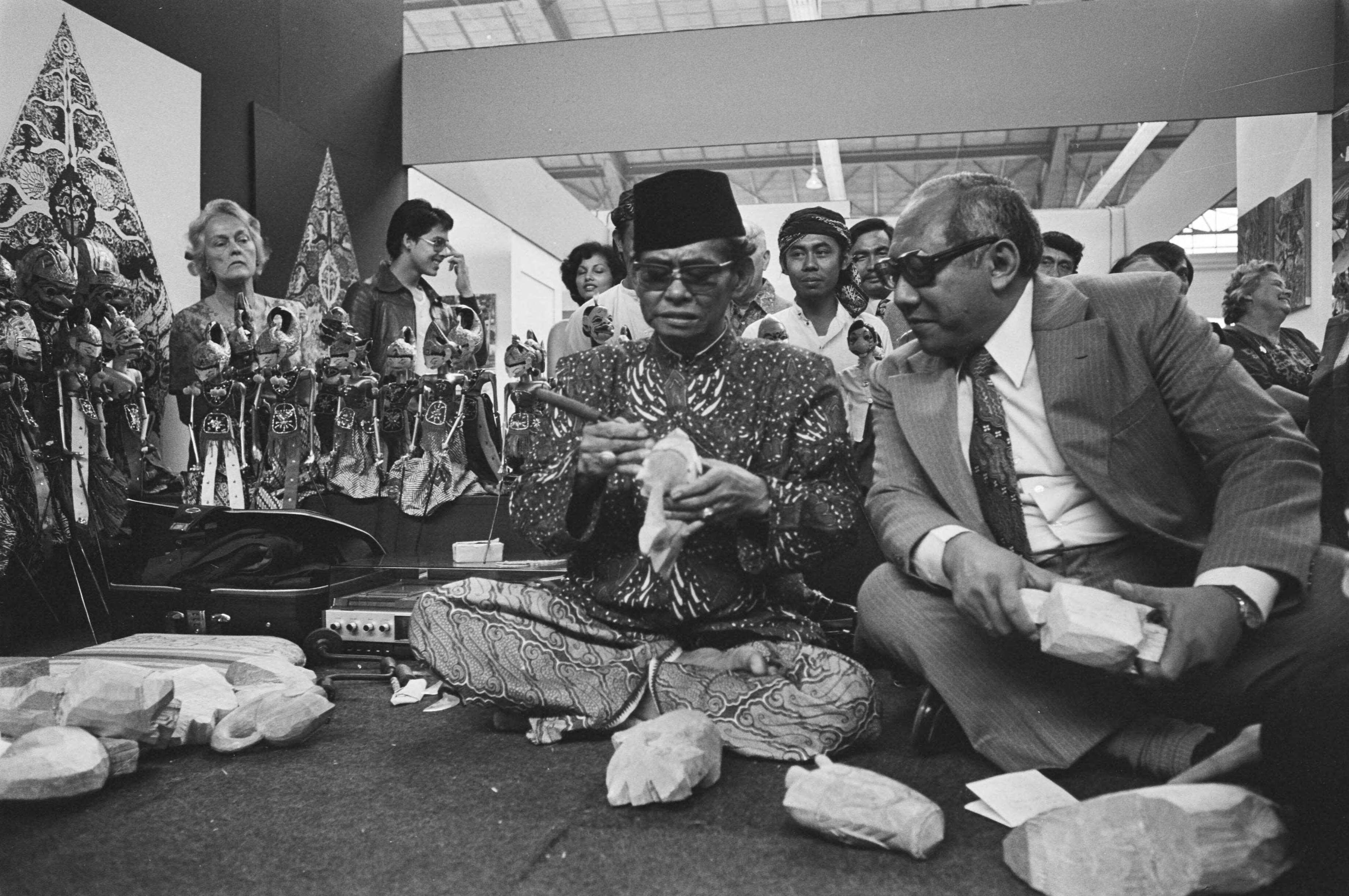 Fotocollectie Anefo — Pasar Malam geopend door ambassadeur Sutopo Yuwono Projohandoko in Den Haag , Sutopo Yuwono Projohandoko en houtsnijder van wayang-poppen — Foto: Peters, Hans / Anefo. Licentie: Set B: Rechtenvrij / Publiek Domein. Bron: Nationaal Archief. http://hdl.handle.net/10648/ac86934a-d0b4-102d-bcf8-003048976d84