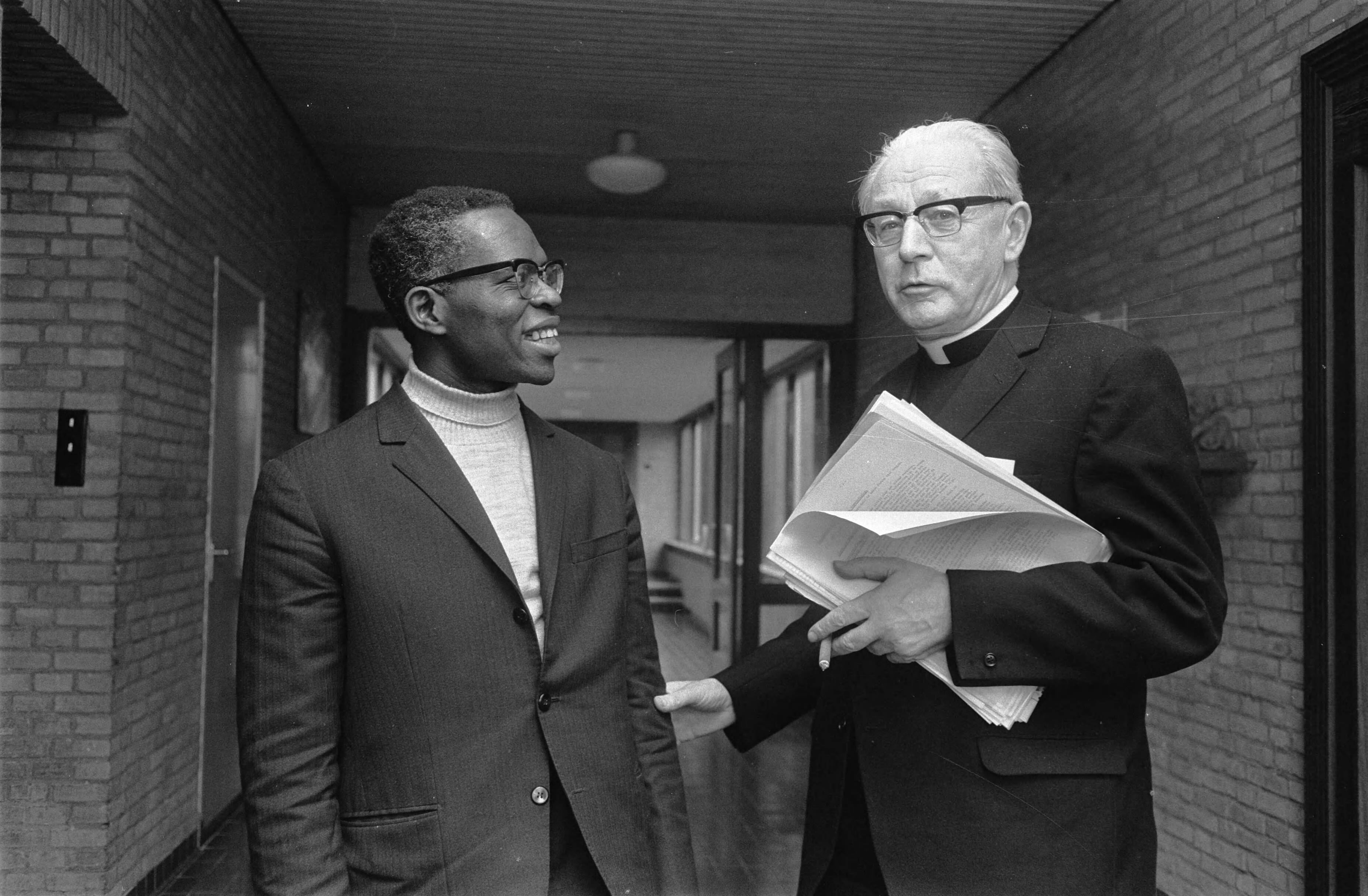 Fotocollectie Anefo — Pastoraal Concilie (laatste) in Noordwijkerhout. Links priester Jose Rafael (Angola) en rechts kardinaal B. J. Alfrink — Foto: Koch, Eric / Anefo. Licentie: Set B: Rechtenvrij / Publiek Domein. Bron: Nationaal Archief. http://hdl.handle.net/10648/ab92e952-d0b4-102d-bcf8-003048976d84