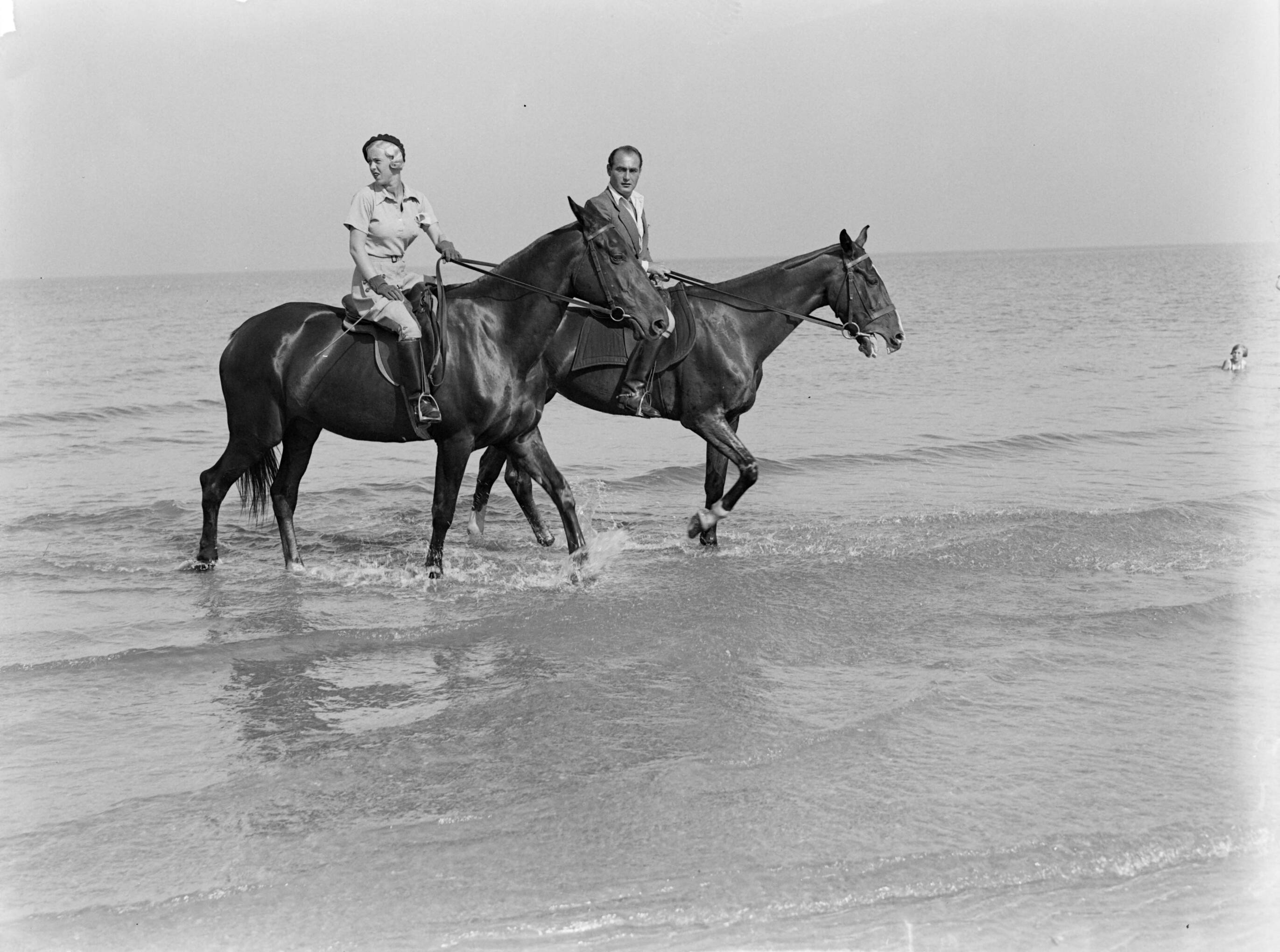 Scheveningen. — Een man (Farrar?) en een vrouw (Yvonne?) te paard op het strand van Scheveningen — Foto: Poll, Willem van de. Licentie: Set B: Rechtenvrij / Publiek Domein. Bron: Nationaal Archief. http://hdl.handle.net/10648/ae9aad88-d0b4-102d-bcf8-003048976d84
