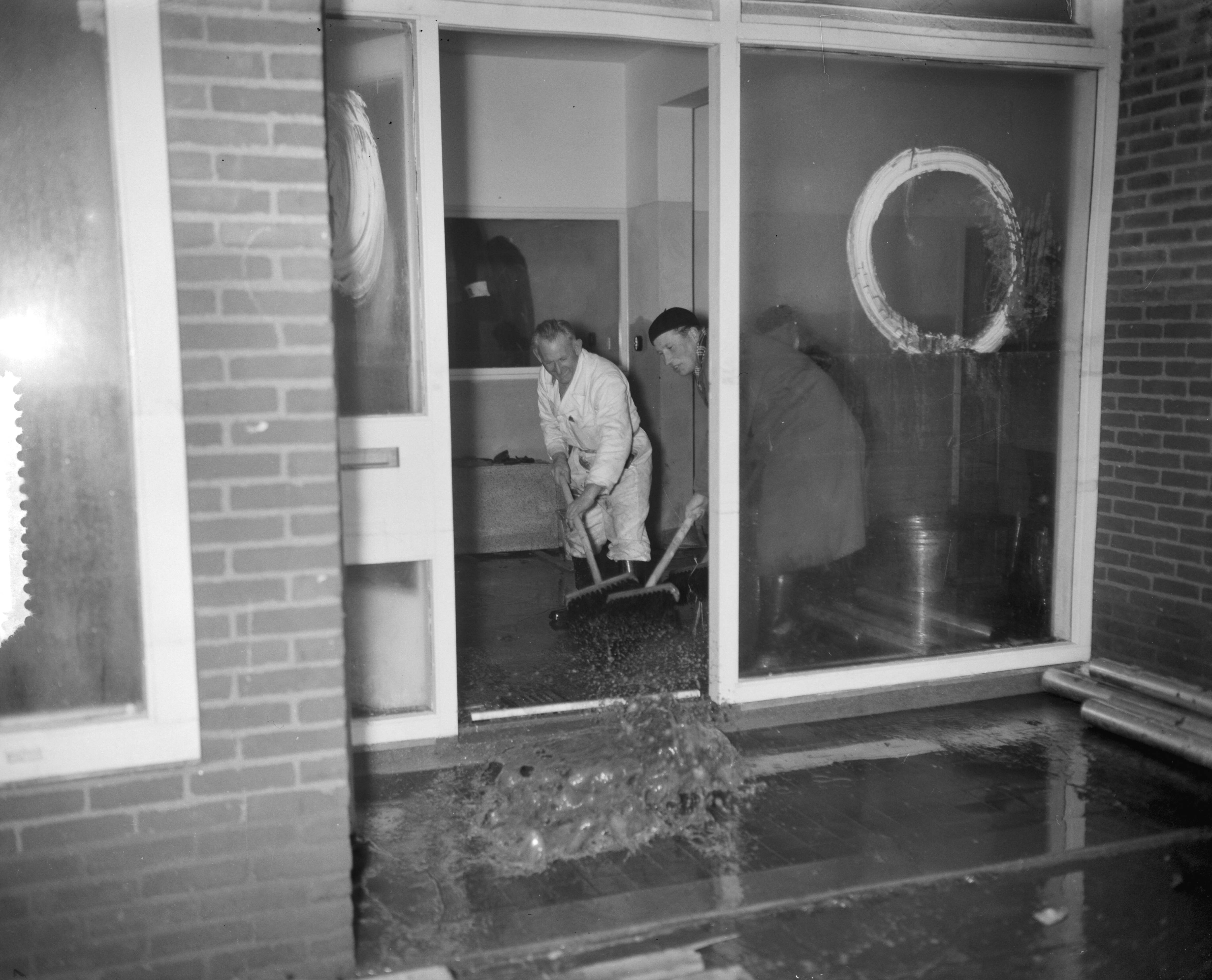 Ramp Tuindorp Oostzaan — Persrondgang door rampgebied Oostzaan, schoonmaken winkelpand — Foto: Bilsen, Joop van / Anefo. Licentie: Set B: Rechtenvrij / Publiek Domein. Bron: Nationaal Archief. http://hdl.handle.net/10648/a9a63f7c-d0b4-102d-bcf8-003048976d84