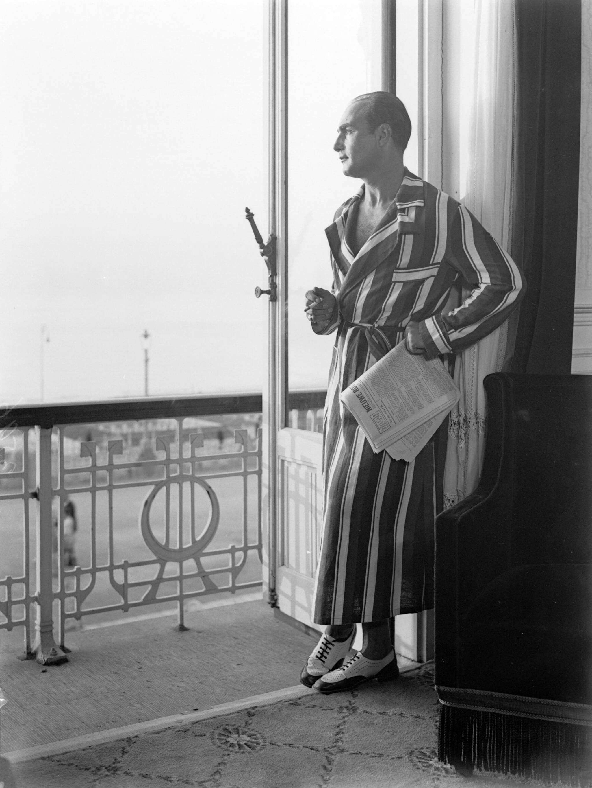 Scheveningen. — Een man kijkt vanuit zijn hotelkamer (in het Palace Hotel?) op de boulevard in Scheveningen — Foto: Poll, Willem van de. Licentie: Set B: Rechtenvrij / Publiek Domein. Bron: Nationaal Archief. http://hdl.handle.net/10648/ae9aab4e-d0b4-102d-bcf8-003048976d84
