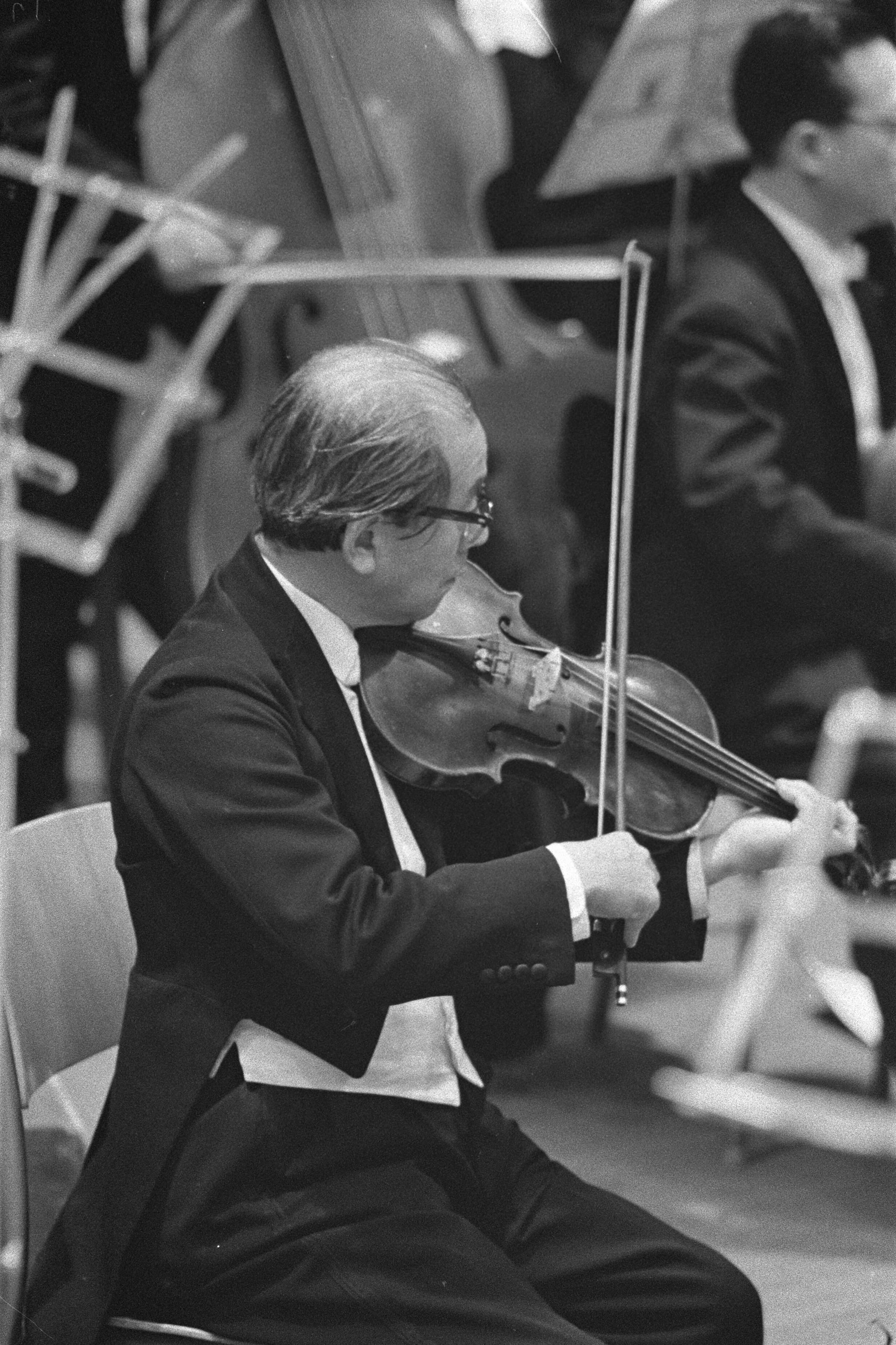 Fotocollectie Anefo — Repetitie Tokyo's Philharmonisch Orkest te Den Haag, een violist — Foto: Pot, Harry / Anefo. Licentie: Set B: Rechtenvrij / Publiek Domein. Bron: Nationaal Archief. http://hdl.handle.net/10648/a9bdb2c4-d0b4-102d-bcf8-003048976d84