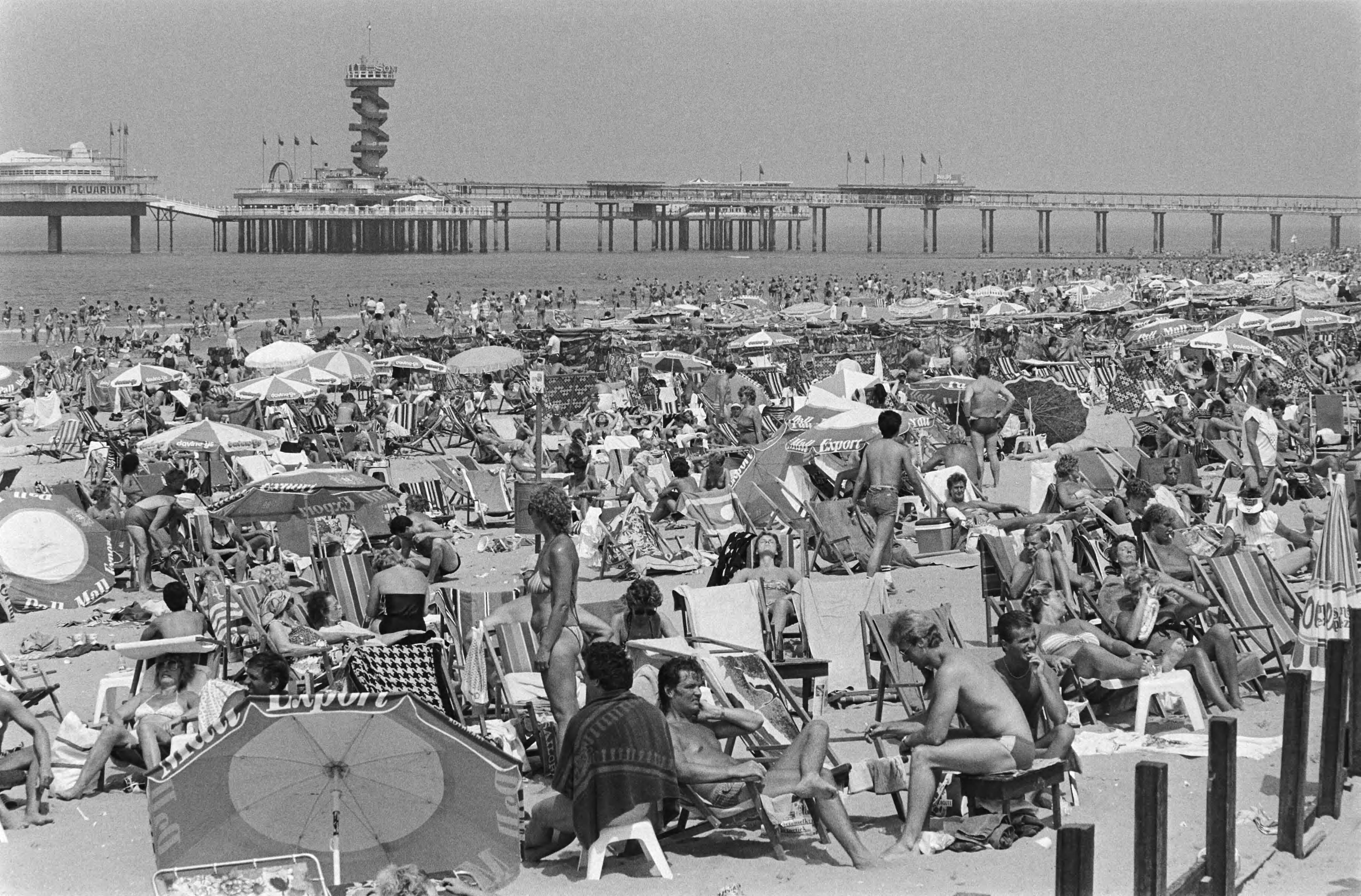 Mooi strandweer — Drukte in Scheveningen; op de achtergrond de Pier — Foto: Antonisse, Marcel / Anefo. Licentie: Set B: Rechtenvrij / Publiek Domein. Bron: Nationaal Archief. http://hdl.handle.net/10648/ad2b71ee-d0b4-102d-bcf8-003048976d84