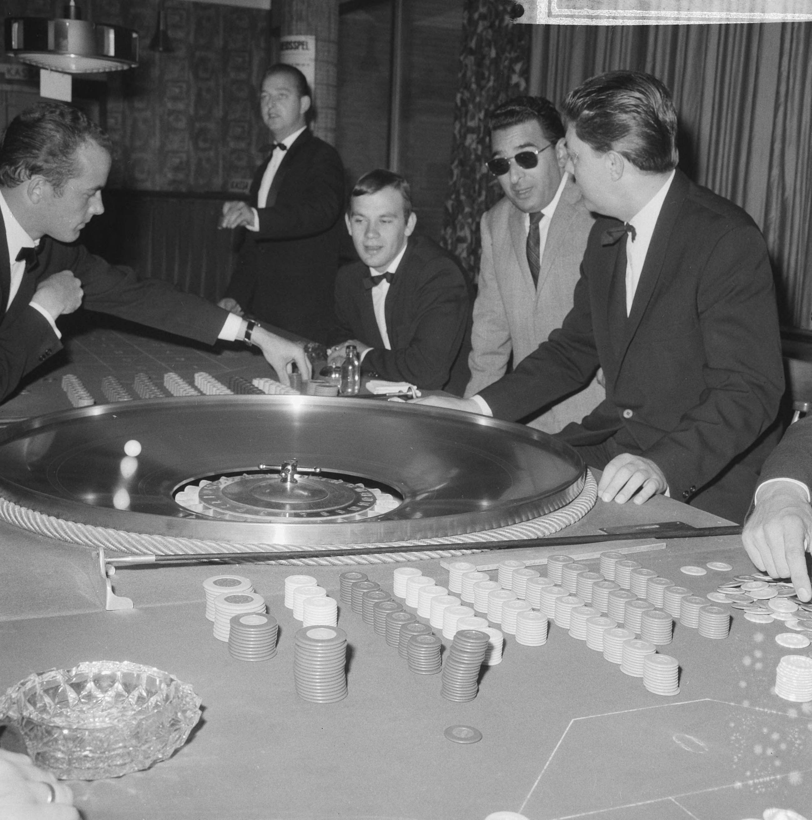 Fotocollectie Anefo — Naar aanleiding van een besluit van het ministerie van Justitie moeten de casino's in Nederland hun deuren sluiten. In West-End te Loosdrecht rolt vandaag voor het laatst het balletje — Foto: Evers, Joost / Anefo. Licentie: Set B: Rechtenvrij / Publiek Domein. Bron: Nationaal Archief. http://hdl.handle.net/10648/aac84b84-d0b4-102d-bcf8-003048976d84