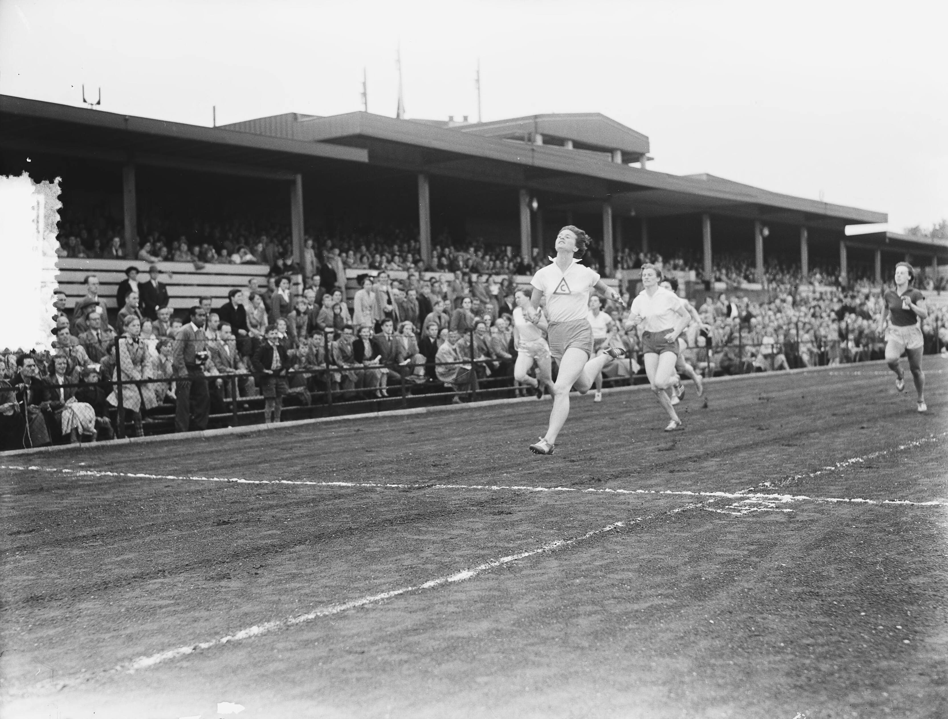 Fotocollectie Anefo — Atletiekwestrijden te Hilversum. Finish 100 meter. Winnares Puck Brouwer. Achter haar o.a. Gré de Jongh (2e) — Foto: Rossem, Wim van / Anefo. Licentie: Set B: Rechtenvrij / Publiek Domein. Bron: Nationaal Archief. http://hdl.handle.net/10648/a90dcada-d0b4-102d-bcf8-003048976d84