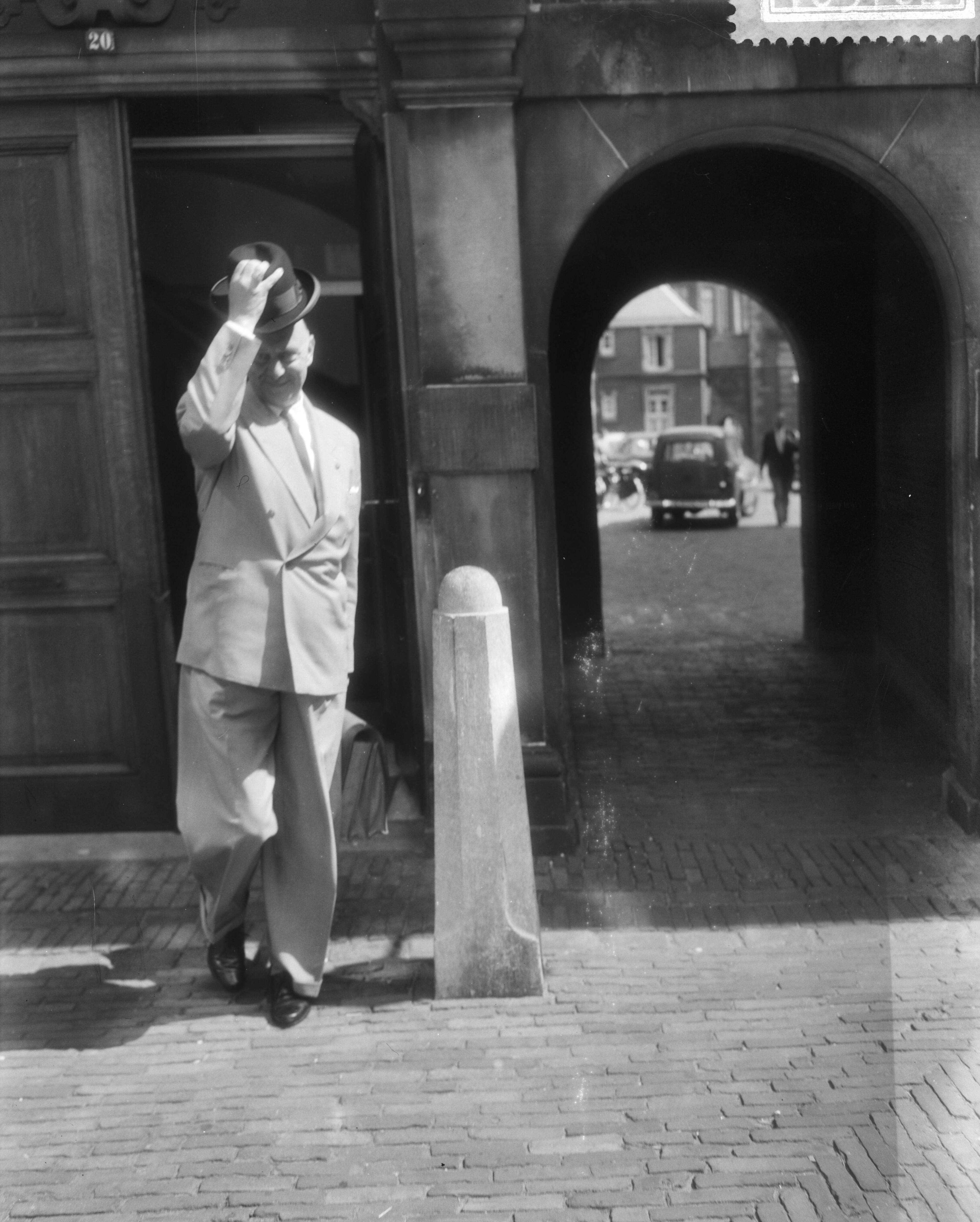 Fotocollectie Anefo — Kabinetsformatie in Den Haag [een man ligt zijn hoed als hij een gebouw op het Binnenhof verlaat[ — Foto: Pot, Harry / Anefo. Licentie: Set B: Rechtenvrij / Publiek Domein. Bron: Nationaal Archief. http://hdl.handle.net/10648/a993de40-d0b4-102d-bcf8-003048976d84