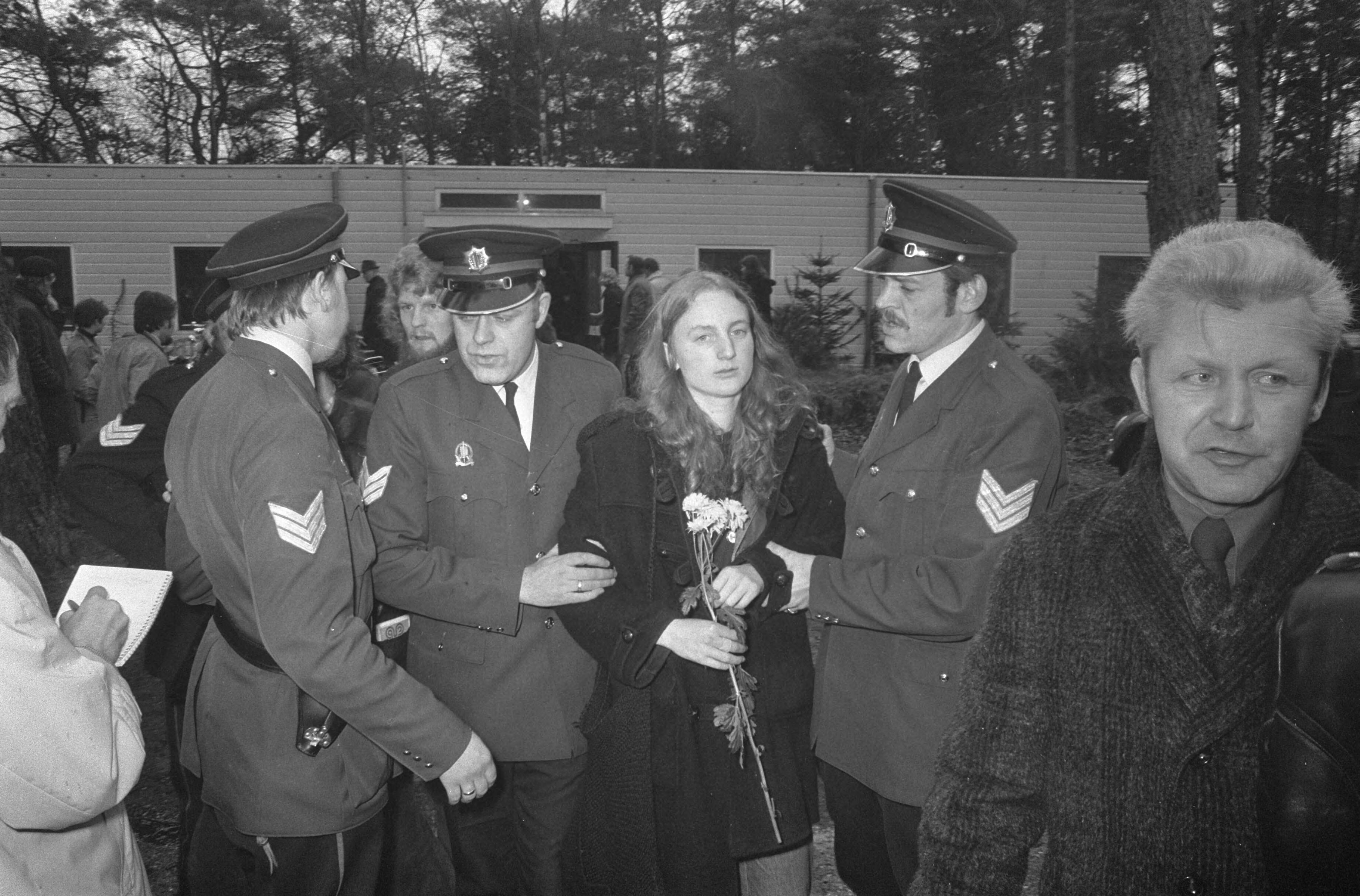 De directiekeet van zwakzinnigeninrichting Dennendal in Den Dolder wordt door de politie ontruimd — Een bezetster wordt weggevoerd — Foto: Fotograaf Onbekend / Anefo. Licentie: Set B: Rechtenvrij / Publiek Domein. Bron: Nationaal Archief. http://hdl.handle.net/10648/ac415bd6-d0b4-102d-bcf8-003048976d84