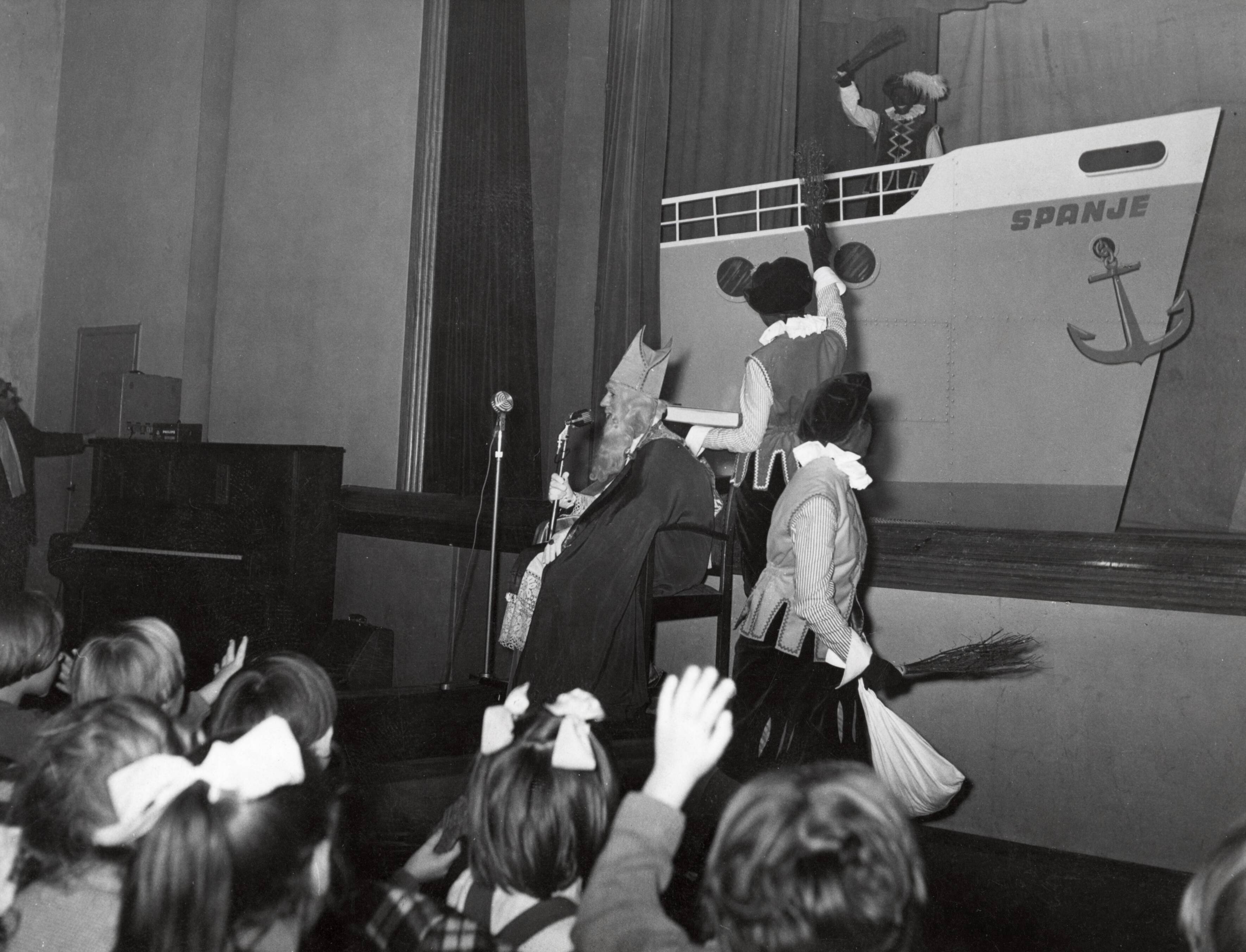 Collectie nader te bepalen — [Sinterklaasfeest N.V. Drukkerij De Spaarnestad in Haarlem] [Sinterklaas en drie Zwarte Pieten met op toneel de voorplecht van de stoomboot] — Foto: Fotograaf Onbekend / Fotobureau onbekend / Spaarnestad Photo (05887). Licentie: Set B: Rechtenvrij / Publiek Domein. Bron: Nationaal Archief. http://hdl.handle.net/10648/35429da6-404b-a382-e063-6df0900a6686
