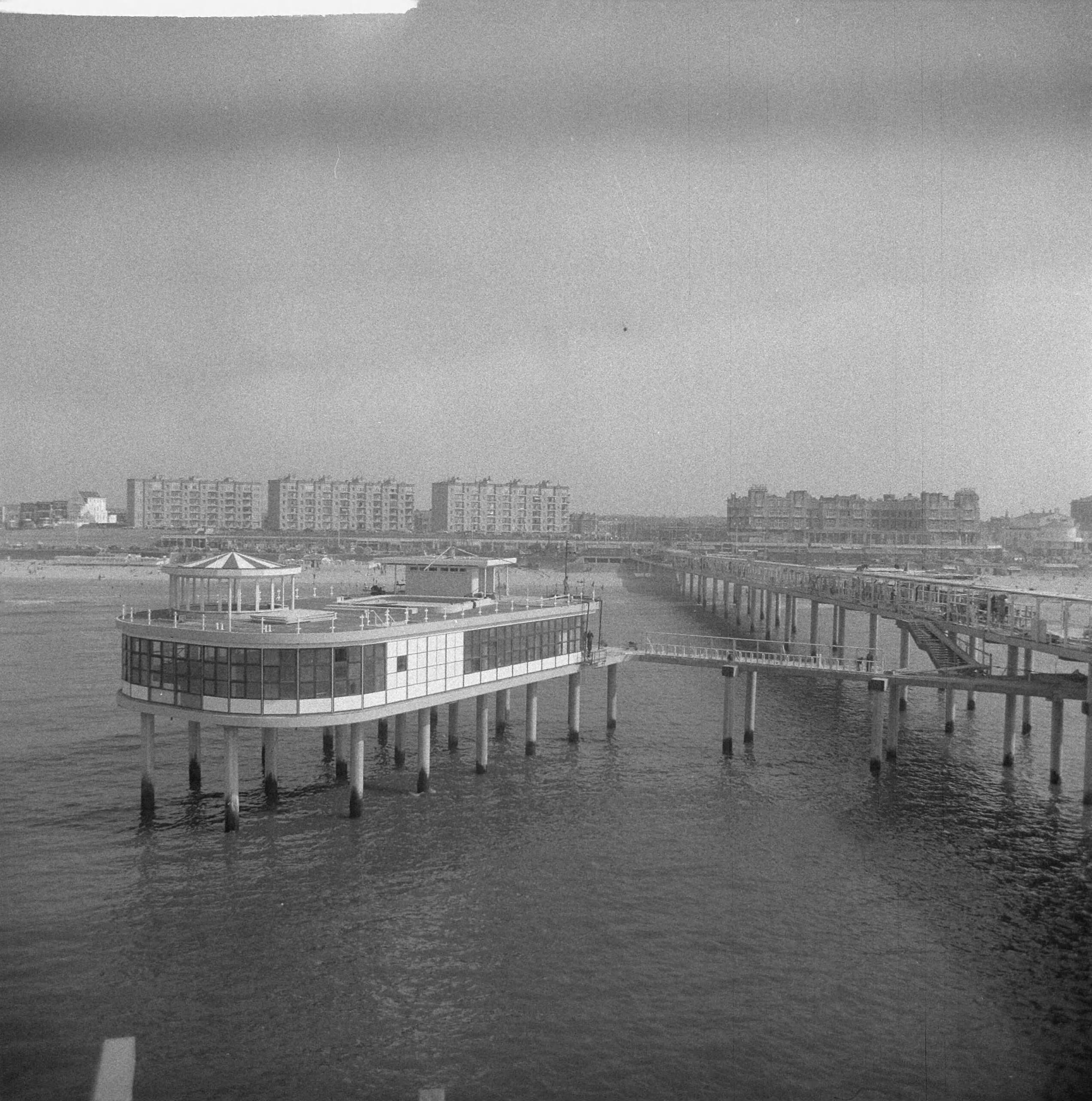 Fotocollectie Anefo — Werkzaamheden Pier te Scheveningen. Overzicht Pier naar het strand — Foto: Nijs, Jac. de / Anefo. Licentie: Set B: Rechtenvrij / Publiek Domein. Bron: Nationaal Archief. http://hdl.handle.net/10648/a9d0f56e-d0b4-102d-bcf8-003048976d84