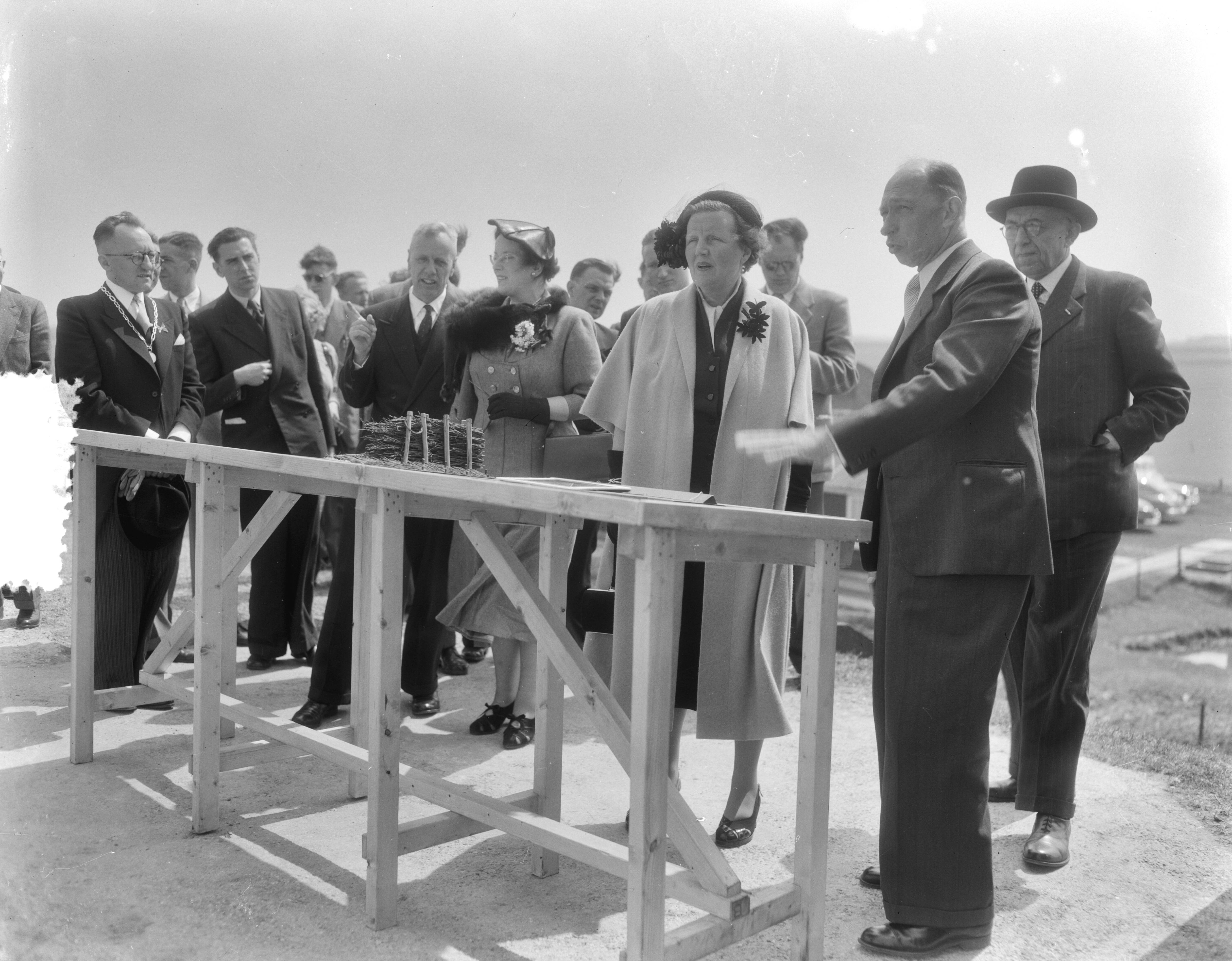 Werkbezoek van koningin Juliana aan de provincie Groningen (1954) — Werkbezoek van koningin Juliana aan de provincie Groningen. Op de zeedijk bij de Julianapolder, waar de koningin een uitzicht had over de Waddenzee en de landaanwinningswerken bekeek. Rechts ir. W. Kooper, hoofdingenieur van Rijkswaterstaat en hoofd van de Dienst Landaanwinningswerken. Links achter de koningin haar particuliere secretaresse mevr. Smitt-Avis. Links burgemeester M.H. Boerland van Kloosterburen — Foto: Duinen, G.W. van / Anefo. Licentie: Set B: Rechtenvrij / Publiek Domein. Bron: Nationaal Archief. http://hdl.handle.net/10648/a9228fba-d0b4-102d-bcf8-003048976d84
