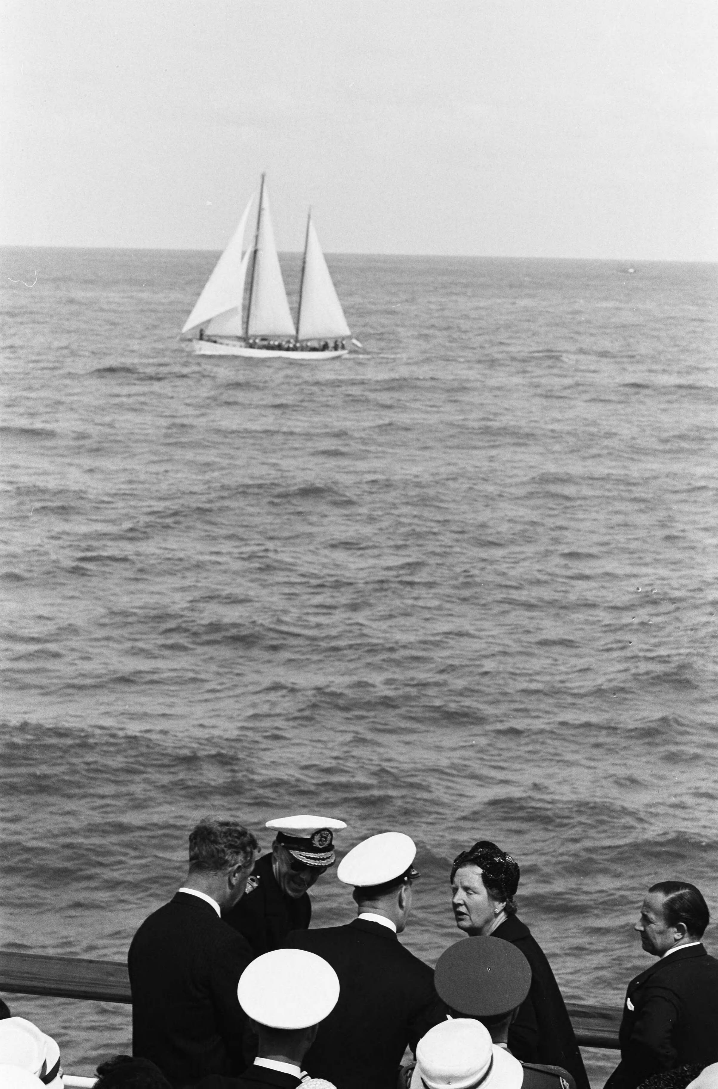 Fotocollectie Anefo — Vlootschouw bij de Scheveningse Pier. Koningin en prins op de Pier. Voorbijvaren van een zeiljacht — Foto: Pot, Harry / Anefo. Licentie: Set B: Rechtenvrij / Publiek Domein. Bron: Nationaal Archief. http://hdl.handle.net/10648/a9db9c62-d0b4-102d-bcf8-003048976d84
