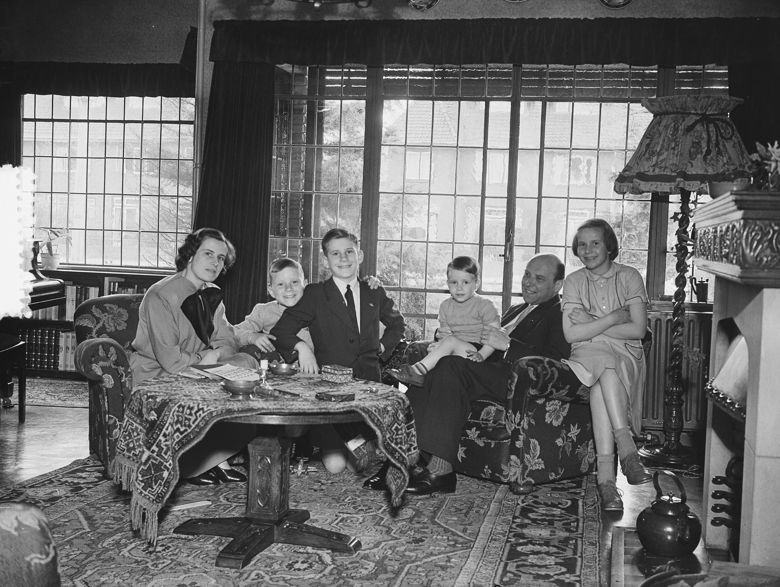 Fotocollectie Anefo — Opnamen familie Smulders Voorburg. Familie poseert in huiskamer — Foto: Bilsen, Joop van / Anefo. Licentie: Set B: Rechtenvrij / Publiek Domein. Bron: Nationaal Archief. http://hdl.handle.net/10648/a90a33c0-d0b4-102d-bcf8-003048976d84