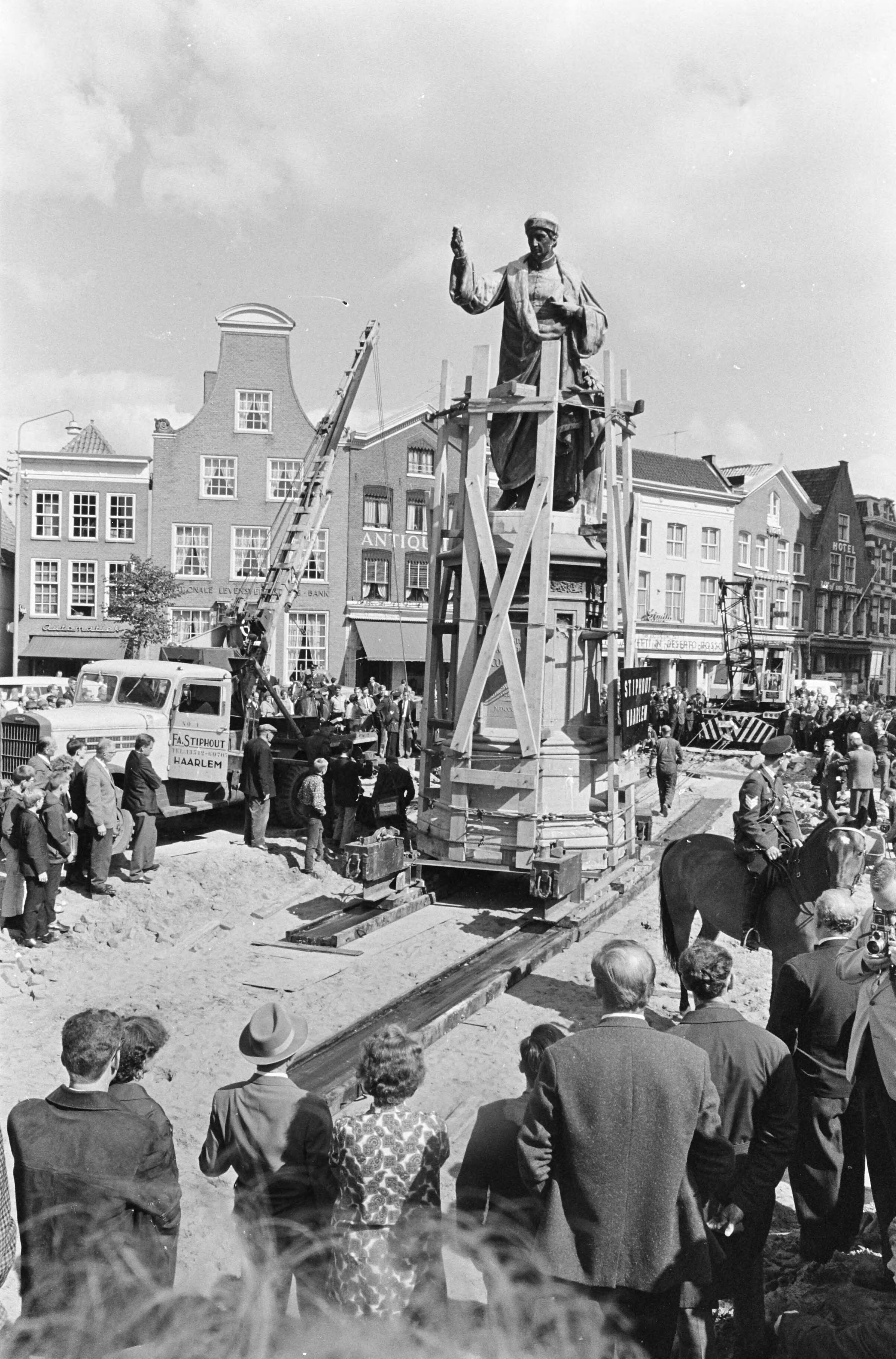 Fotocollectie Anefo — Standbeeld van Laurens Janszoon Coster wordt op de markt in Haarlem verplaatst — Foto: Kroon, Ron / Anefo. Licentie: Set B: Rechtenvrij / Publiek Domein. Bron: Nationaal Archief. http://hdl.handle.net/10648/aafc0168-d0b4-102d-bcf8-003048976d84