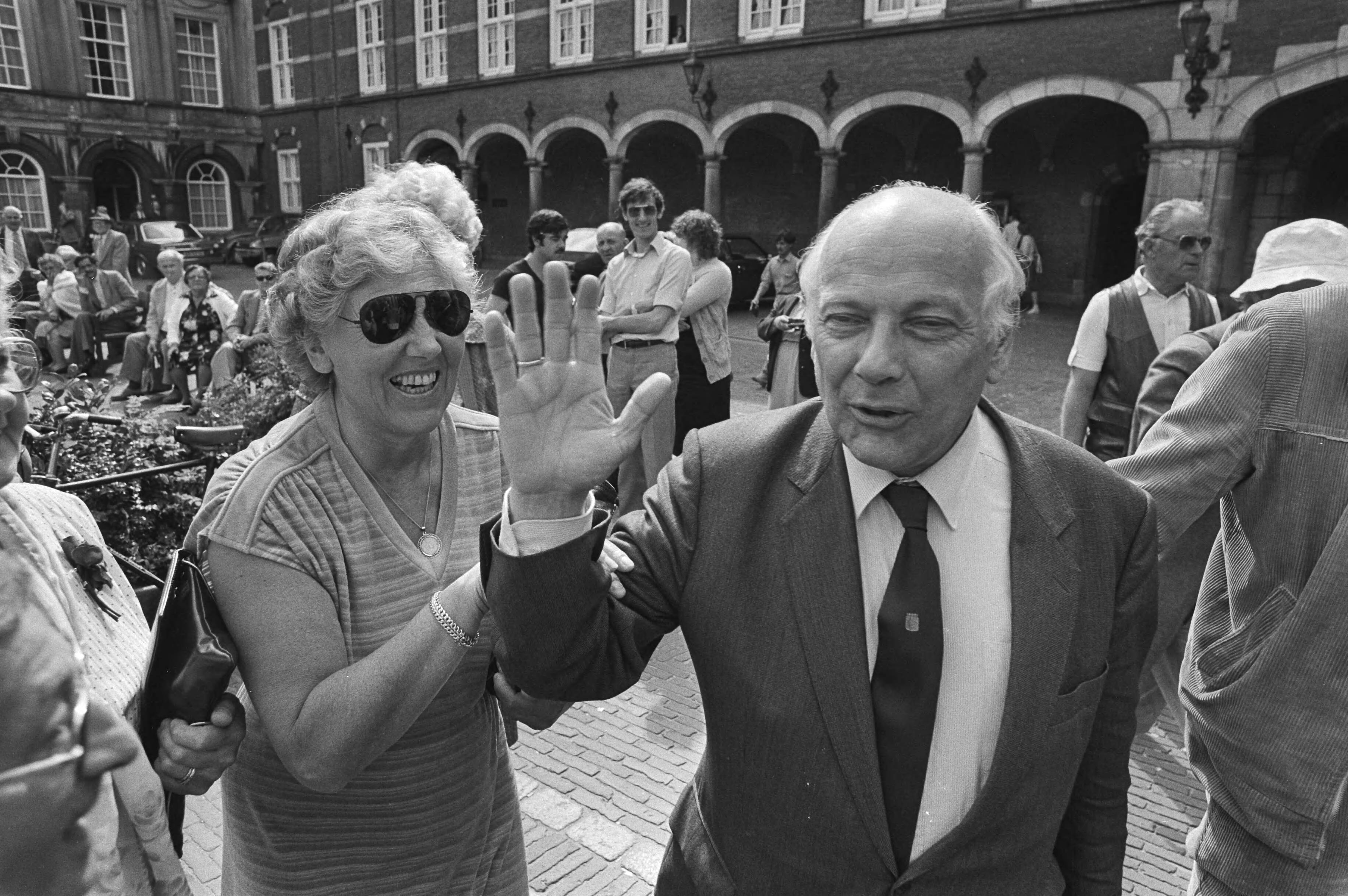 Kabinetsformatie 1981 — Een vrolijke PvdA fractievoorzitter Joop den Uyl met een vrouw op het Binnenhof in den Haag tijdens de kabinetsformatie van 1981 — Foto: Antonisse, Marcel / Anefo. Licentie: Set B: Rechtenvrij / Publiek Domein. Bron: Nationaal Archief. http://hdl.handle.net/10648/ad02abce-d0b4-102d-bcf8-003048976d84