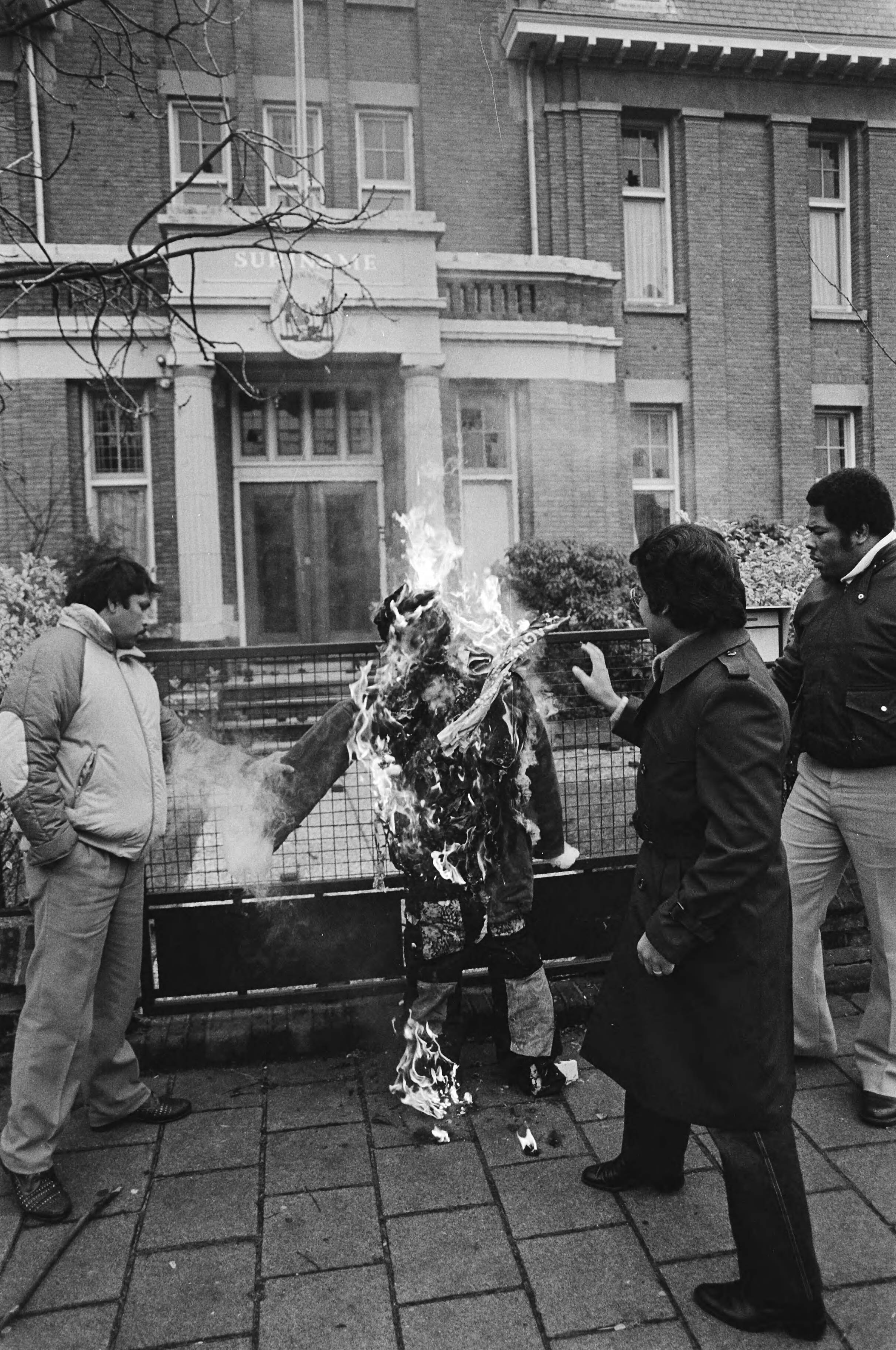 Demonstratie na de Decembermoorden in Suriname voor de Surinaamse Ambassade in Den Haag — Pop, Bouterse voorstellende wordt verbrand — Foto: Antonisse, Marcel / Anefo. Licentie: Set B: Rechtenvrij / Publiek Domein. Bron: Nationaal Archief. http://hdl.handle.net/10648/ad230874-d0b4-102d-bcf8-003048976d84