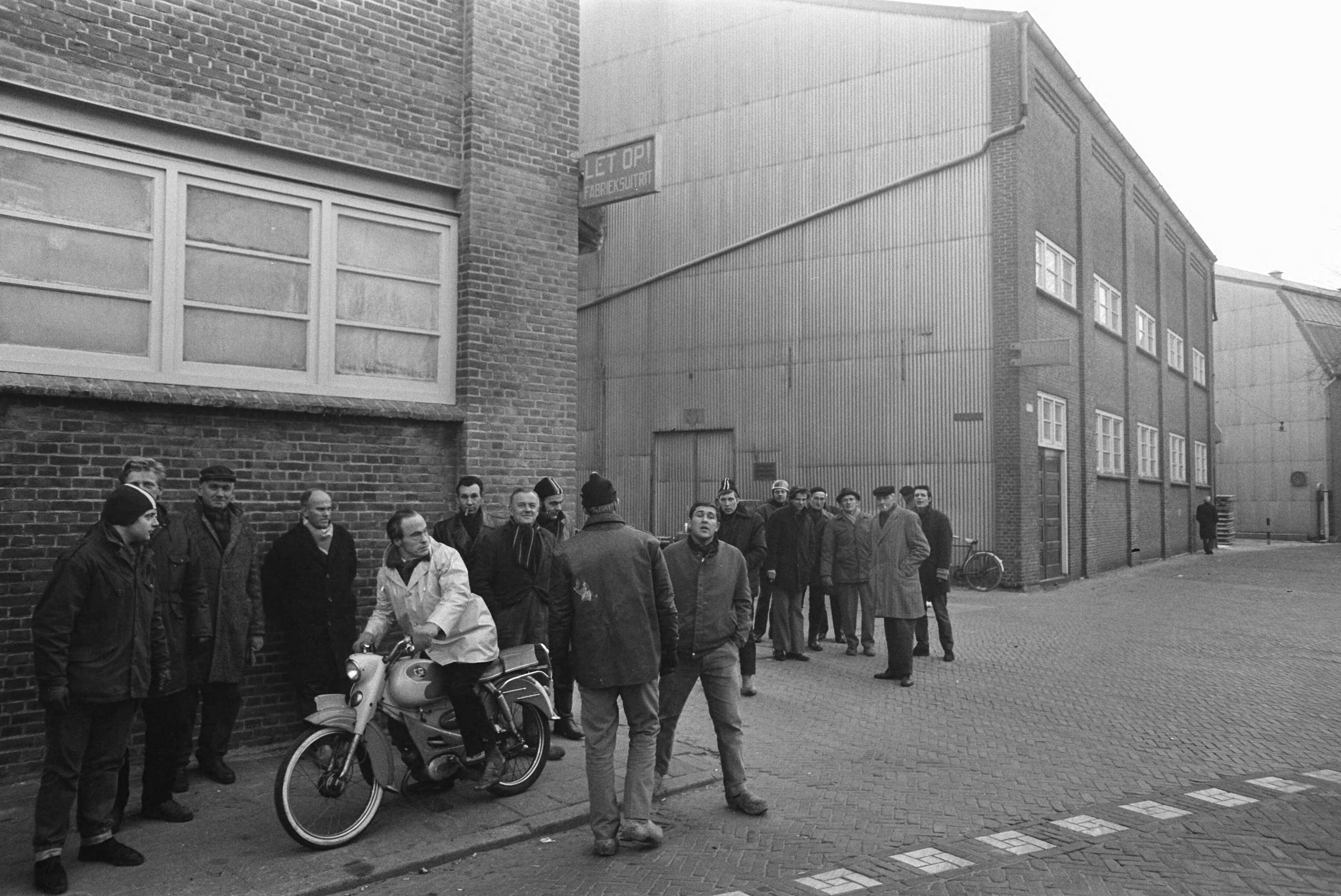 Fotocollectie Anefo — Werknemers van Honing in Koog aan de Zaan staken voor 1% duurtetoeslag en werktijdverkorting aan eind van de dag. Stakers io get bedruhfsterreub — Foto: Evers, Joost / Anefo. Licentie: Set B: Rechtenvrij / Publiek Domein. Bron: Nationaal Archief. http://hdl.handle.net/10648/ab863c34-d0b4-102d-bcf8-003048976d84