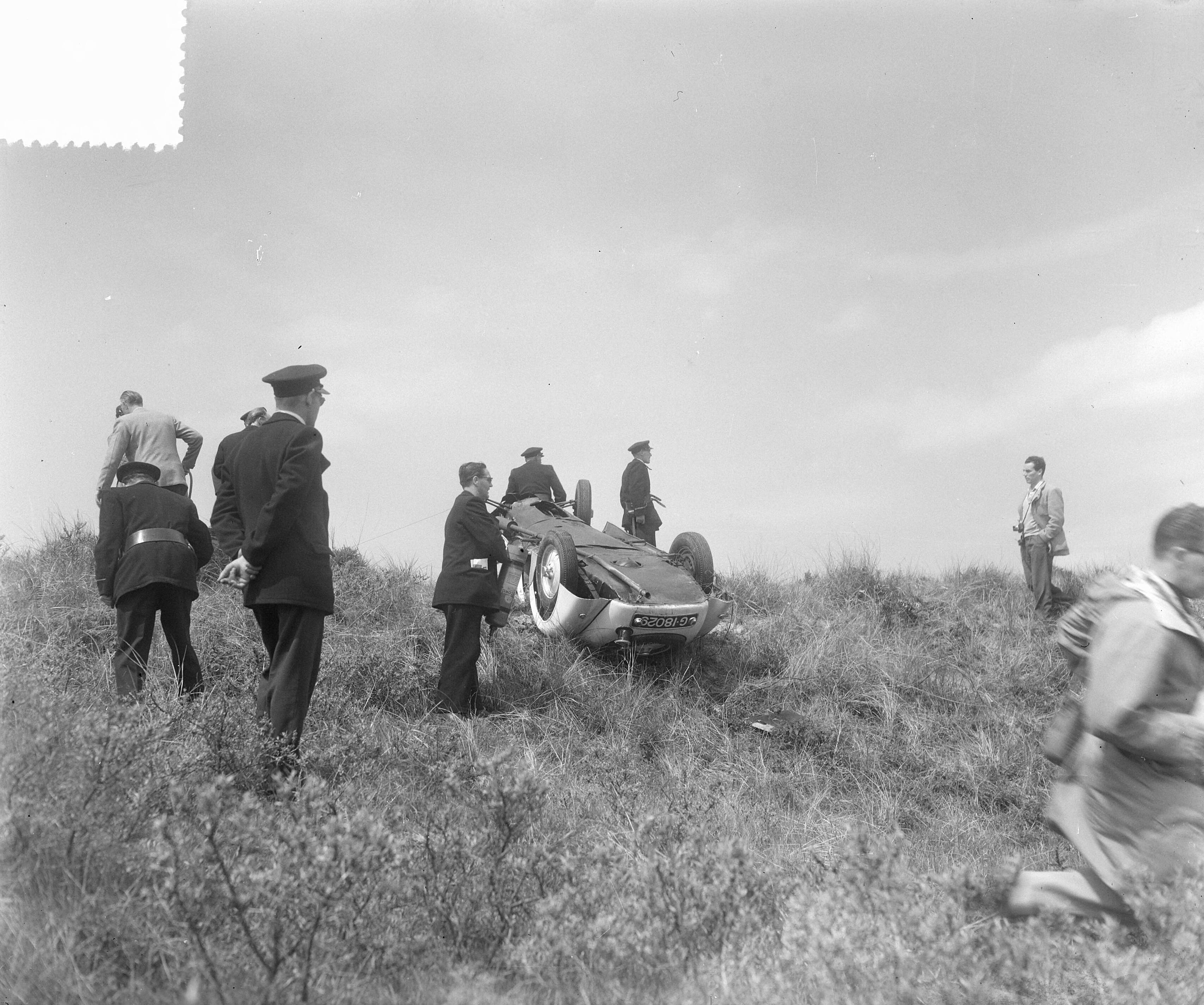 Grand Prix Zandvoort 1953 — Sportwagenrace Zandvoort. De Nederlandse coureur Beemsterboer kwam met zijn BMW in het zand naast de baan terecht, slipte en sloeg viermaal over de kop. Beemsterboer werd uit de auto geslingerd. Hij was slechts licht gewond — Foto: Pot, Harry / Anefo. Licentie: Set B: Rechtenvrij / Publiek Domein. Bron: Nationaal Archief. http://hdl.handle.net/10648/a90d55be-d0b4-102d-bcf8-003048976d84