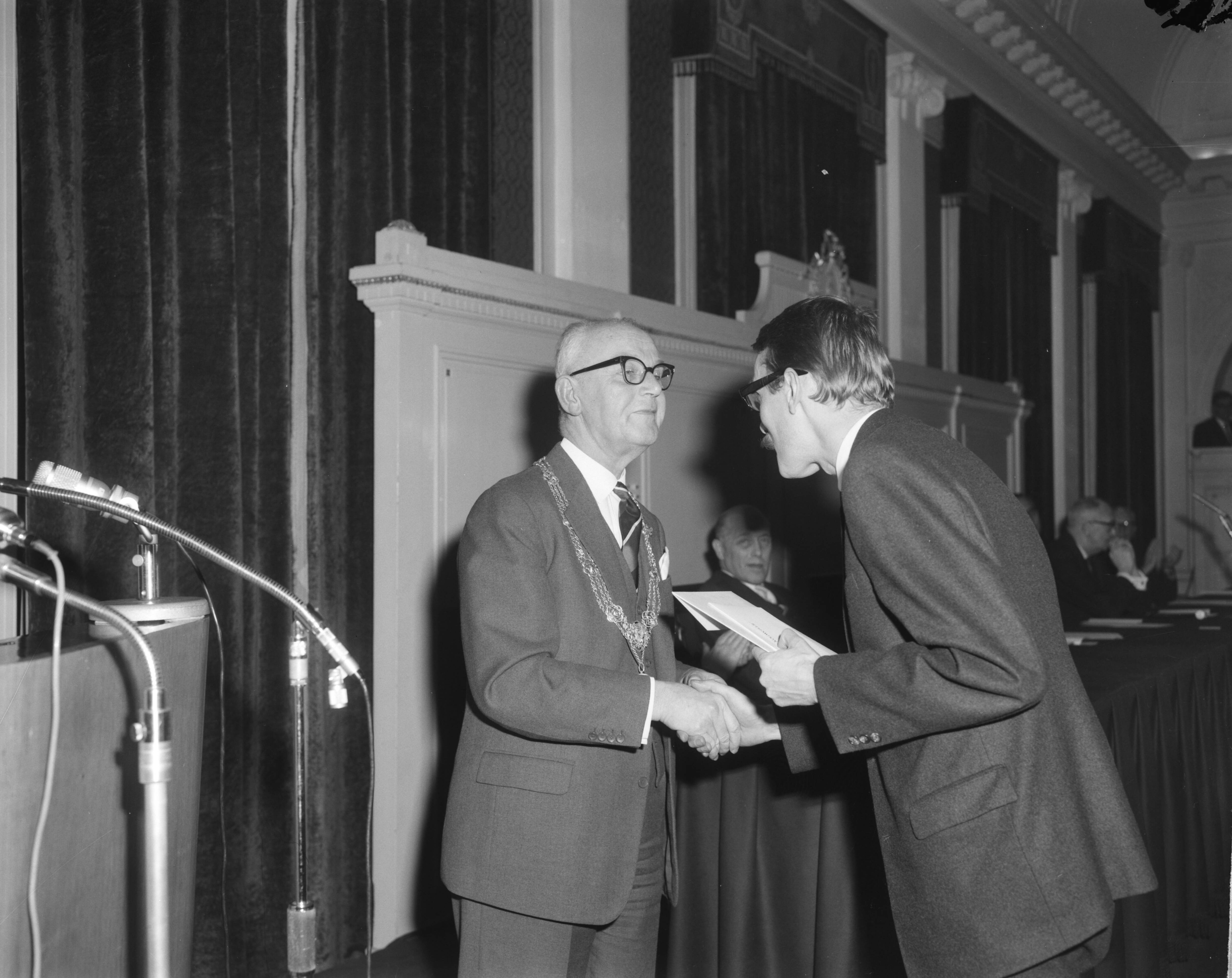 Fotocollectie Anefo — Prijsuitreiking Jan Campertprijs in Den Haag, burgemeester Kolfschoten overhandigt Gerrit Kouwenaar de Jan Campertprijs — Foto: Koch, Eric / Anefo. Licentie: Set B: Rechtenvrij / Publiek Domein. Bron: Nationaal Archief. http://hdl.handle.net/10648/aa231d58-d0b4-102d-bcf8-003048976d84