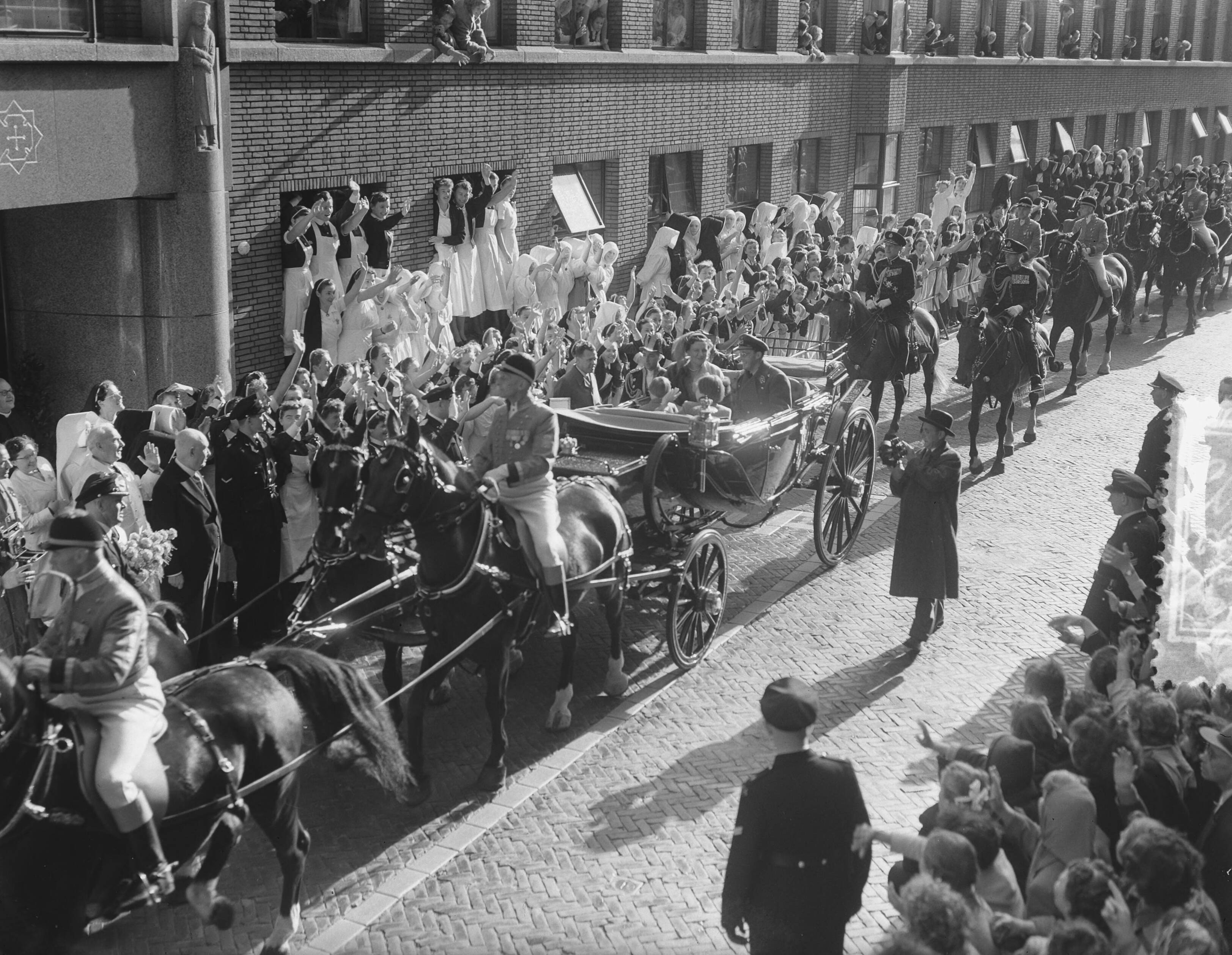 Prinsjesdag 1954 — Opening Staten Generaal. Rijtoer van de koninklijke familie door Den Haag — Foto: Bilsen, Joop van / Anefo. Licentie: Set B: Rechtenvrij / Publiek Domein. Bron: Nationaal Archief. http://hdl.handle.net/10648/a929db6c-d0b4-102d-bcf8-003048976d84
