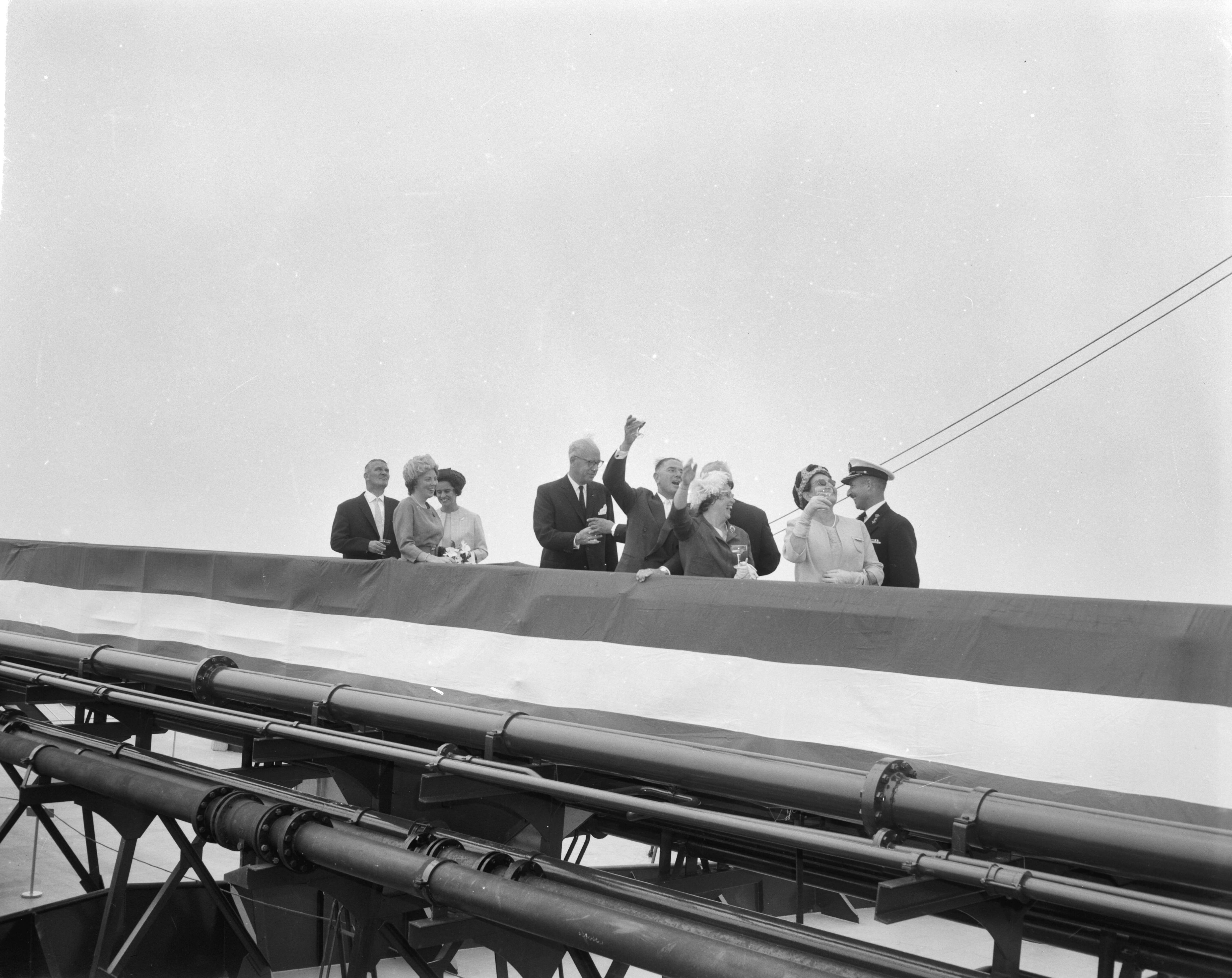 Fotocollectie Anefo — Prinses Beatrix doopte de grootste tanker "Esso Den Haag" op de Noordzee. De prinses heeft het schip gedoopt en heft het glas. Geheel links (een glas aannemend) de president-directeur van Esso Nederland, C.R. Smit, voor hem (juichend) Cornelis Verolme — Foto: Bilsen, Joop van / Anefo. Licentie: Set B: Rechtenvrij / Publiek Domein. Bron: Nationaal Archief. http://hdl.handle.net/10648/aa3dc4a0-d0b4-102d-bcf8-003048976d84