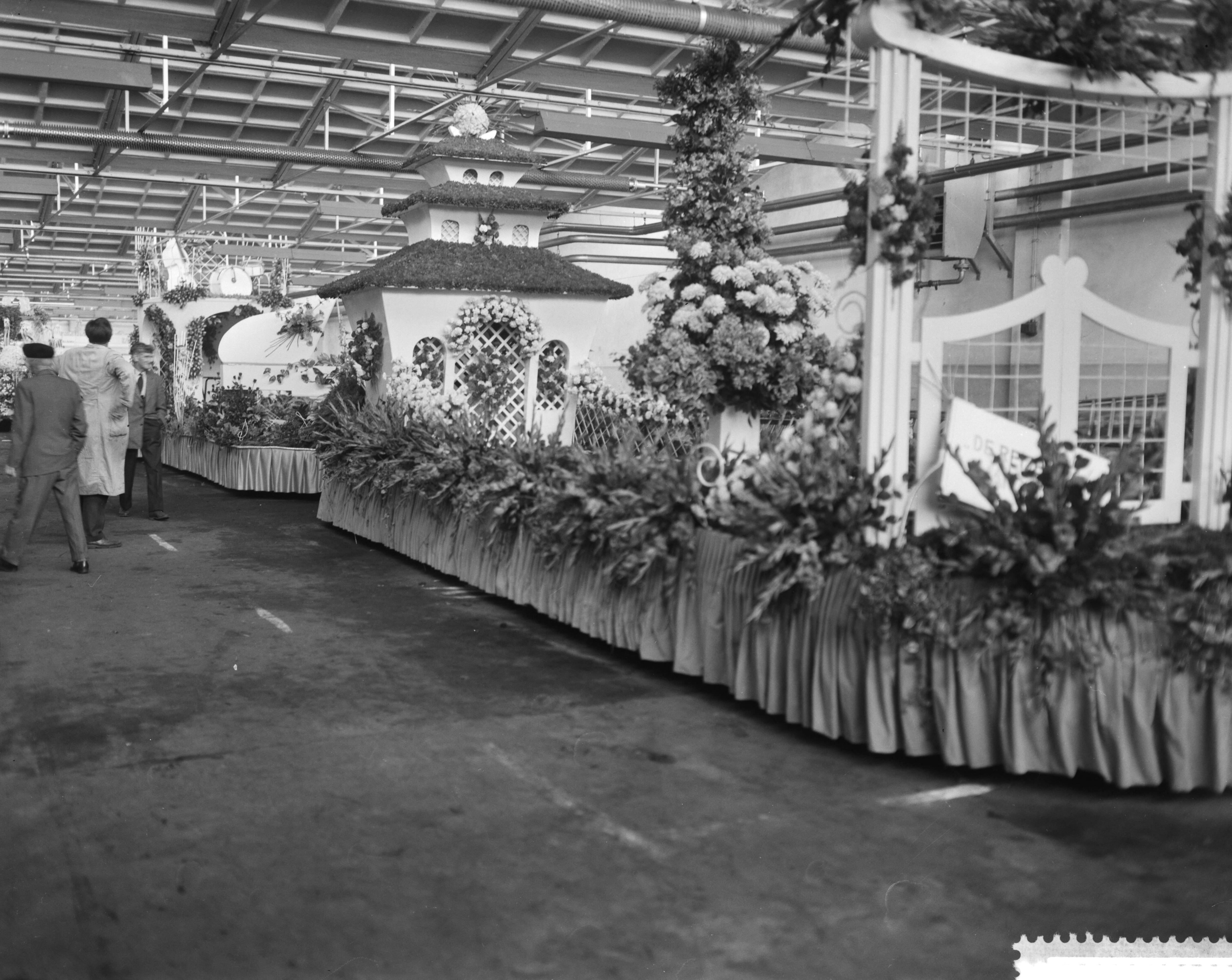 Fotocollectie Anefo — Praalwagens worden opgesierd in de Aalsmeerder veilinghallen voor het bloemencorso — Foto: Bilsen, Joop van / Anefo. Licentie: Set B: Rechtenvrij / Publiek Domein. Bron: Nationaal Archief. http://hdl.handle.net/10648/a9b844e2-d0b4-102d-bcf8-003048976d84