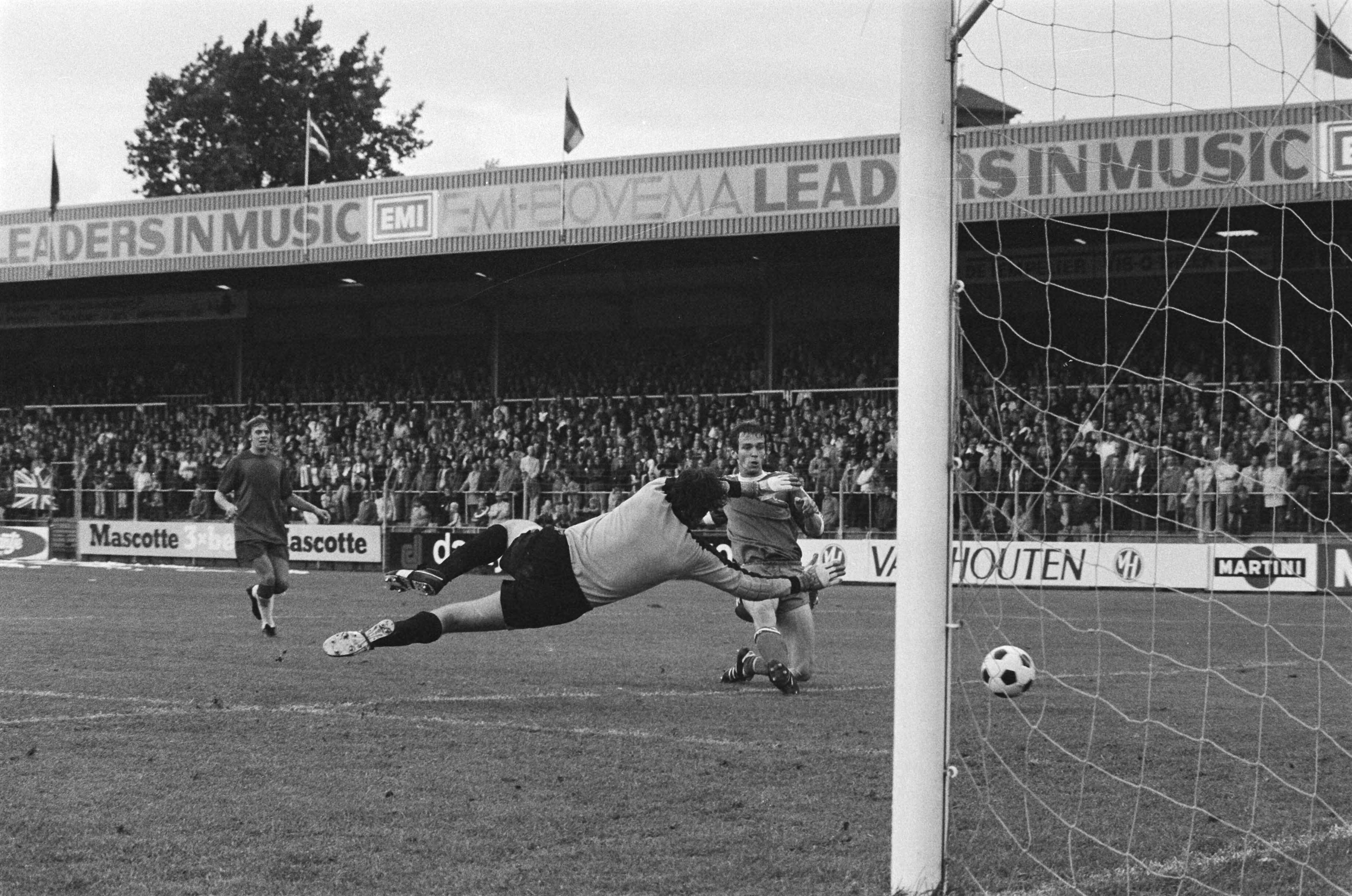 Fotocollectie Anefo — Haarlem tegen PSV; Paul Postuma scoort voor PSV het derde doelpunt, keeper Boersma van Haarlem duikt tevergeefs — Foto: Suyk, Koen / Anefo. Licentie: Set B: Rechtenvrij / Publiek Domein. Bron: Nationaal Archief. http://hdl.handle.net/10648/acbaf608-d0b4-102d-bcf8-003048976d84