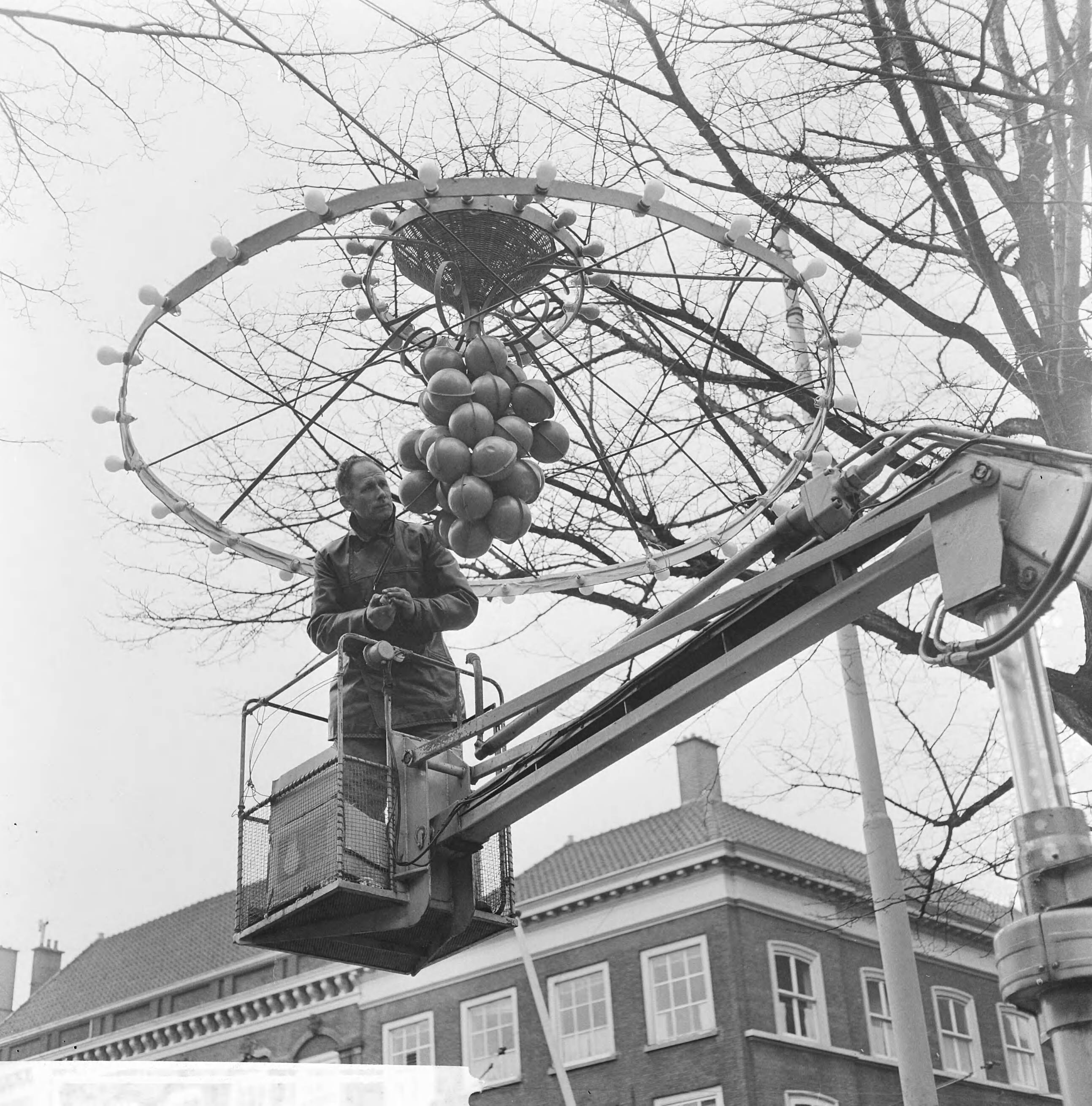 Fotocollectie Anefo — Den Haag maakt zich mooi, een electricien controleert de lampjes — Foto: Kroon, Ron / Anefo. Licentie: Set B: Rechtenvrij / Publiek Domein. Bron: Nationaal Archief. http://hdl.handle.net/10648/aad9fcee-d0b4-102d-bcf8-003048976d84
