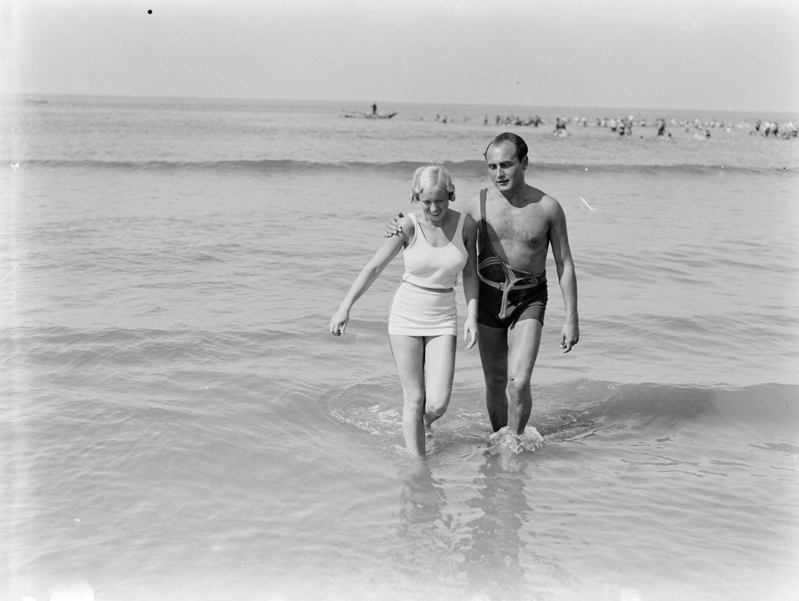 Scheveningen. — Een man (Farrar?) en een vrouw (Yvonne?) in de zee van Scheveningen — Foto: Poll, Willem van de. Licentie: Set B: Rechtenvrij / Publiek Domein. Bron: Nationaal Archief. http://hdl.handle.net/10648/ae9aaf0e-d0b4-102d-bcf8-003048976d84