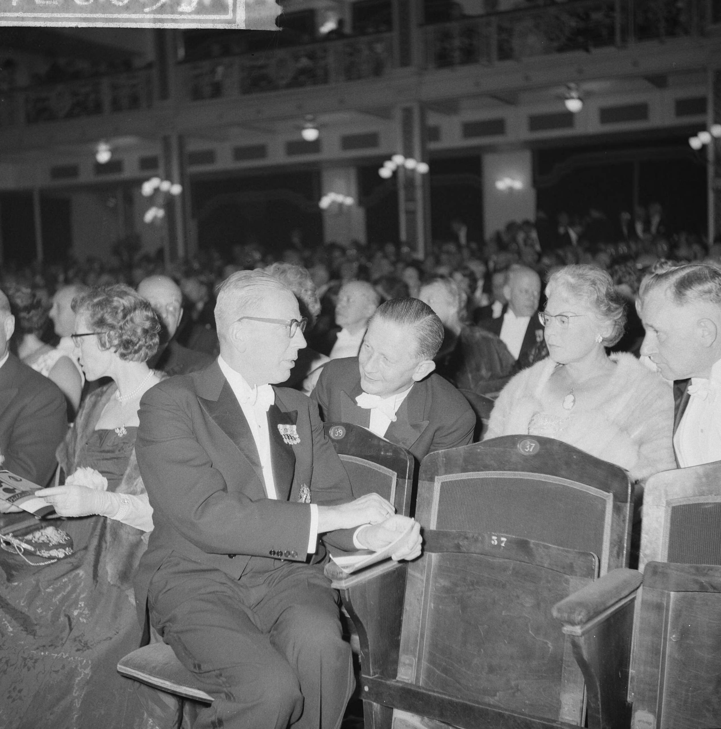 Opening Holland Festival 1961 in het Kurhaus — Opening Holland Festival 1961 in het Kurhaus te Scheveningen. Hoge gasten in het publiek. Minister Beerman spreekt met staatssecretaris Y. Scholten — Foto: Lindeboom, Henk / Anefo. Licentie: Set B: Rechtenvrij / Publiek Domein. Bron: Nationaal Archief. http://hdl.handle.net/10648/a9d8c7a8-d0b4-102d-bcf8-003048976d84