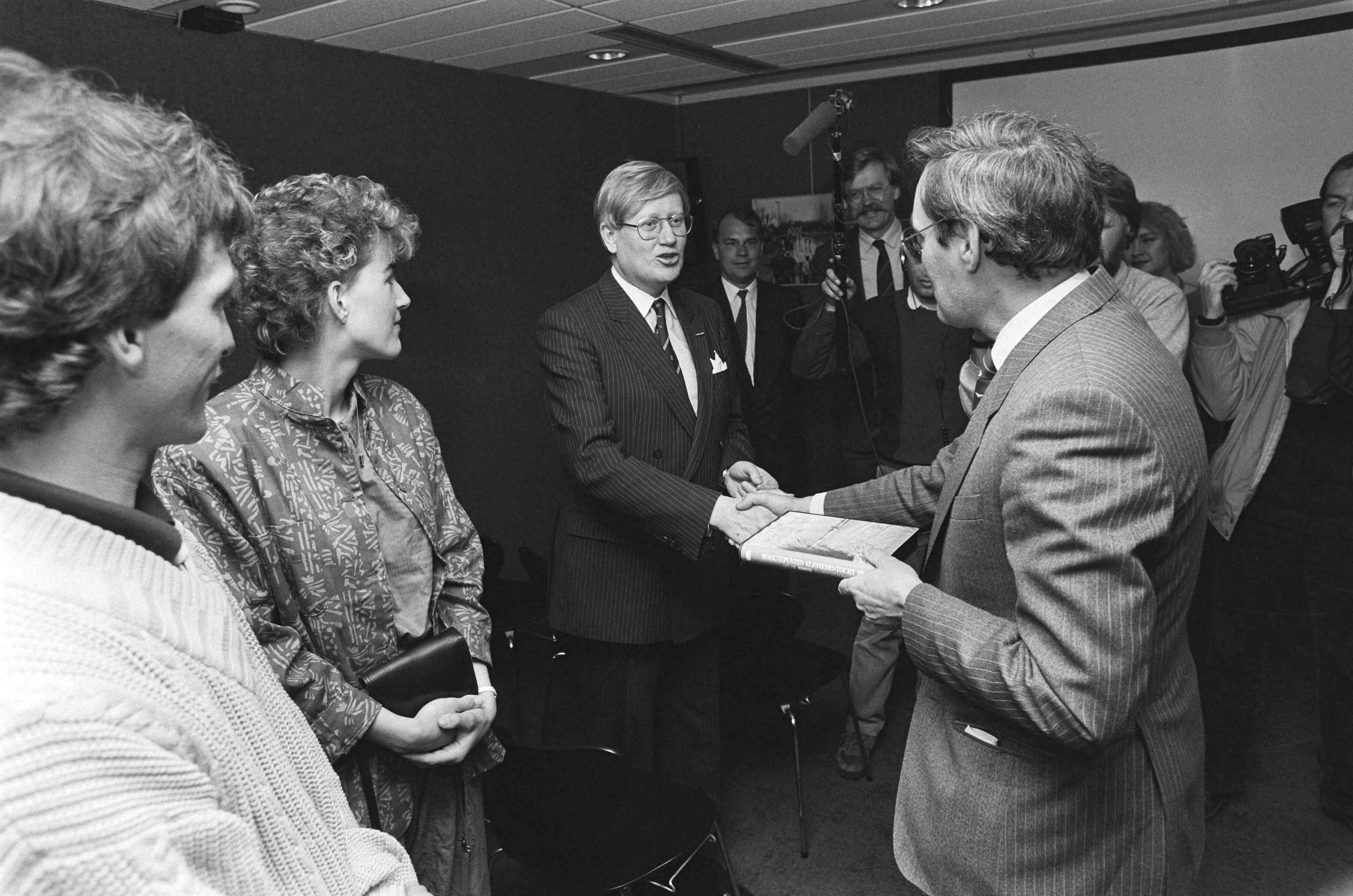 Mr. Pieter van Vollenhoven ontvangt de eerste videocassette van de Elfstedentocht — Hans Wiegel, Evert en Jeanette van Benthem, Hans Wiegel — Foto: Bogaerts, Rob / Anefo. Licentie: Set B: Rechtenvrij / Publiek Domein. Bron: Nationaal Archief. http://hdl.handle.net/10648/ad5087cc-d0b4-102d-bcf8-003048976d84
