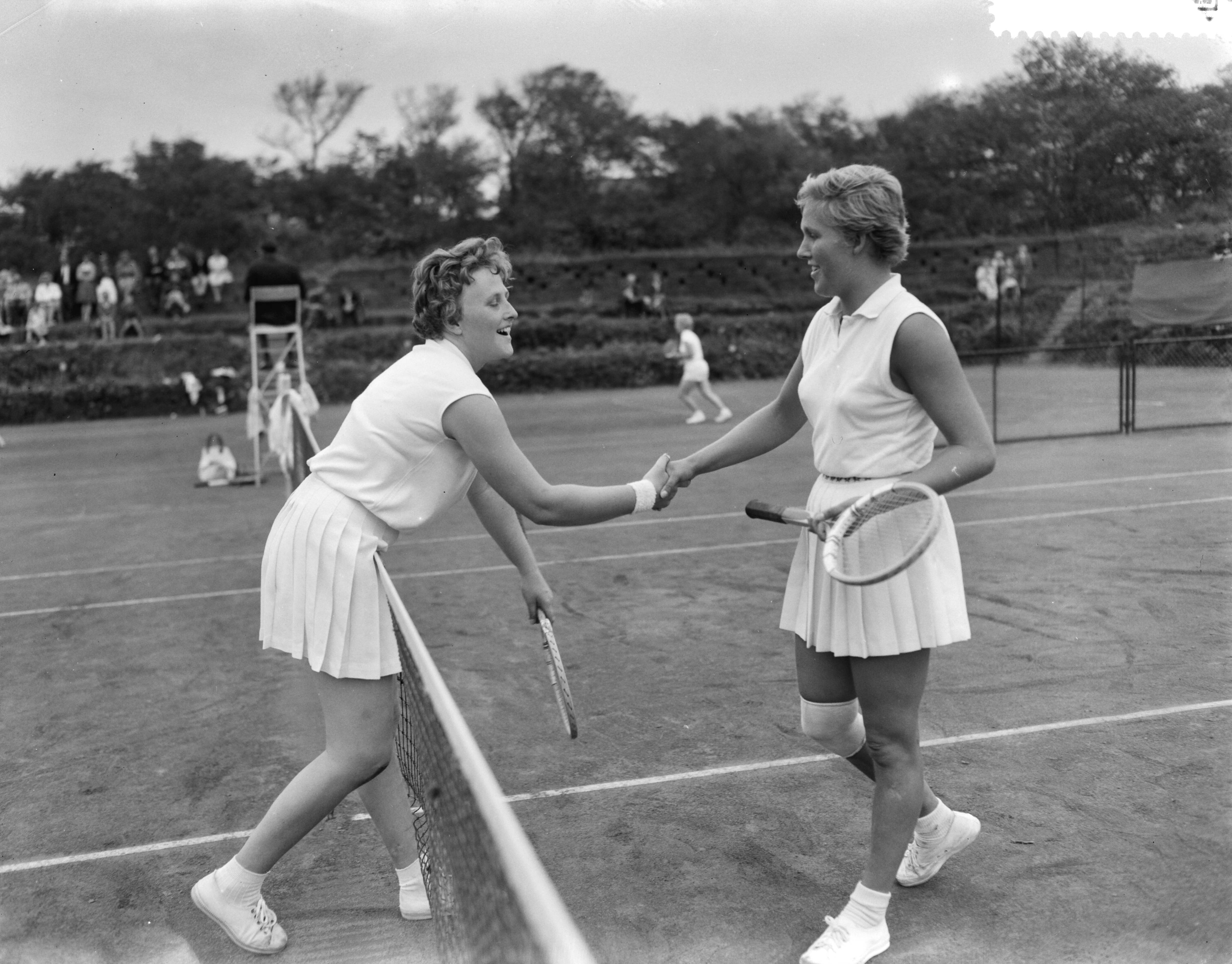 Fotocollectie Anefo — Nationale tenniskampioenschappen op de METS-banen te Scheveningen, Joyce Marinkelle (rechts) schudt de hand van haar tegenstandster Henriëtte Ruinen, nadat ze haar verslagen heeft in een marathonpartij (5-7, 7-5, 10-8) — Foto: Bilsen, Joop van / Anefo. Licentie: Set B: Rechtenvrij / Publiek Domein. Bron: Nationaal Archief. http://hdl.handle.net/10648/a9b6dab2-d0b4-102d-bcf8-003048976d84