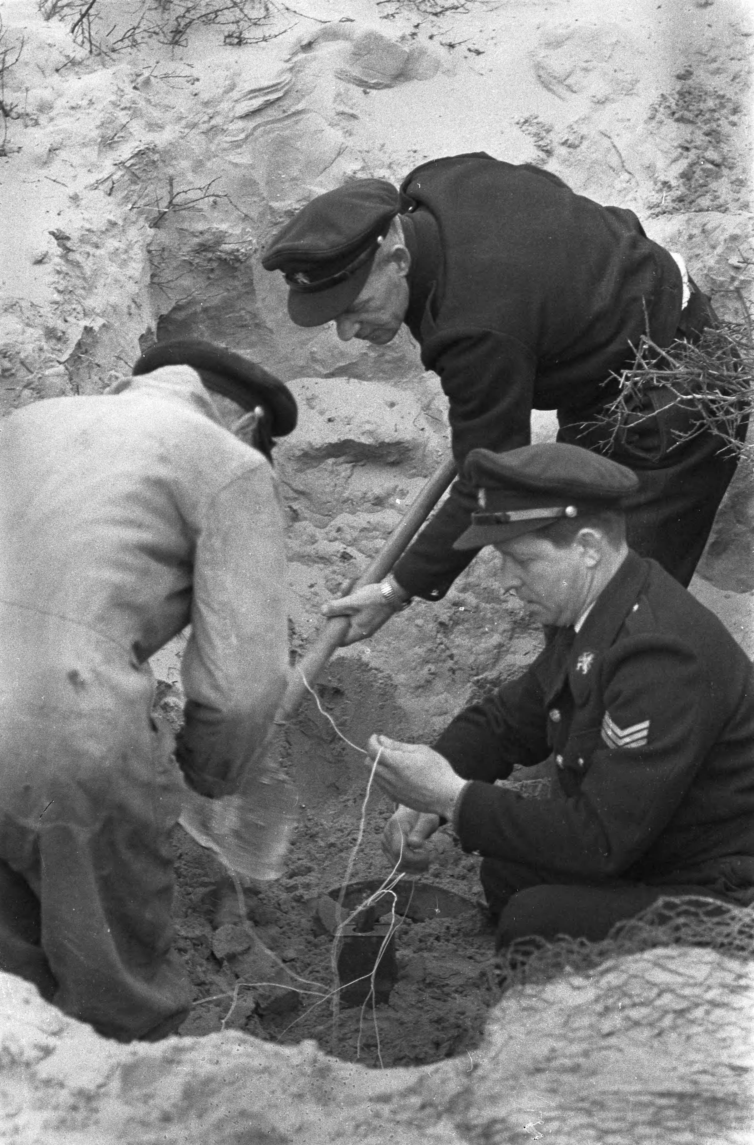 Fotocollectie Anefo — Vliegtuigbom van 1.000 kg tot ontploffing gebracht in de Kennemerduinen bij Haarlem, mannen van de opruimingsdienst demonteren de ontsteking / — Foto: Pot, Harry / Anefo. Licentie: Set B: Rechtenvrij / Publiek Domein. Bron: Nationaal Archief. http://hdl.handle.net/10648/a9aa6af2-d0b4-102d-bcf8-003048976d84