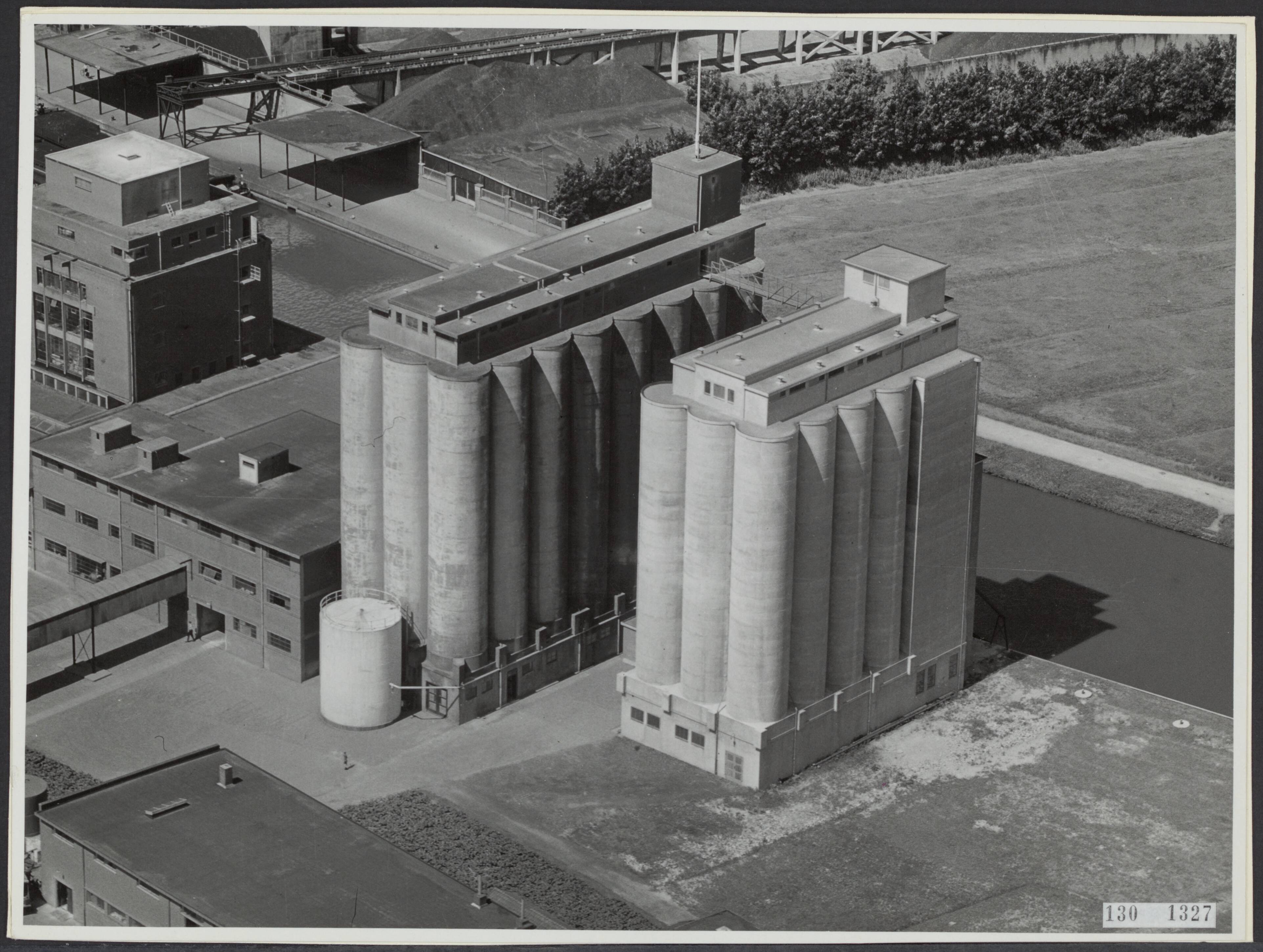 Fotocollectie Rijksvoorlichtingsdienst Eigen — Luchtopname. Graansilo's te Leeuwarden [[Koopmans Meelfabrieken aan het Nieuwe Kanaal] — Foto: KLM Aerocarto / Rechtenvrij. Licentie: Set B: Rechtenvrij / Publiek Domein. Bron: Nationaal Archief. http://hdl.handle.net/10648/af4dbaf4-d0b4-102d-bcf8-003048976d84