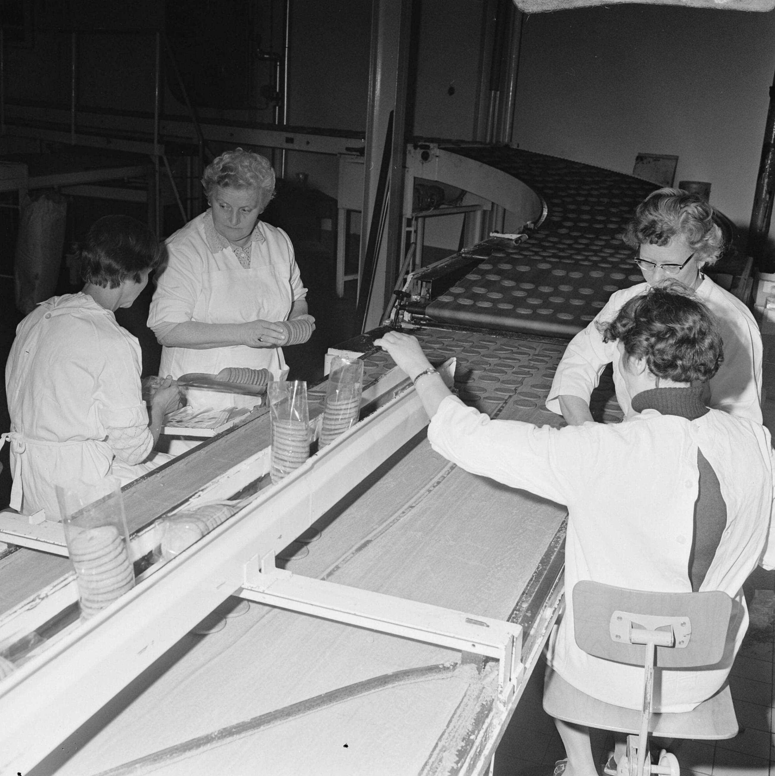 Fotocollectie Anefo — Opdracht Elsevier getrouwde vrouwen aan het werk aan lopende band bij Albert Heyn (Zaandam) — Foto: Mieremet, Rob / Anefo. Licentie: Set B: Rechtenvrij / Publiek Domein. Bron: Nationaal Archief. http://hdl.handle.net/10648/ab622e48-d0b4-102d-bcf8-003048976d84