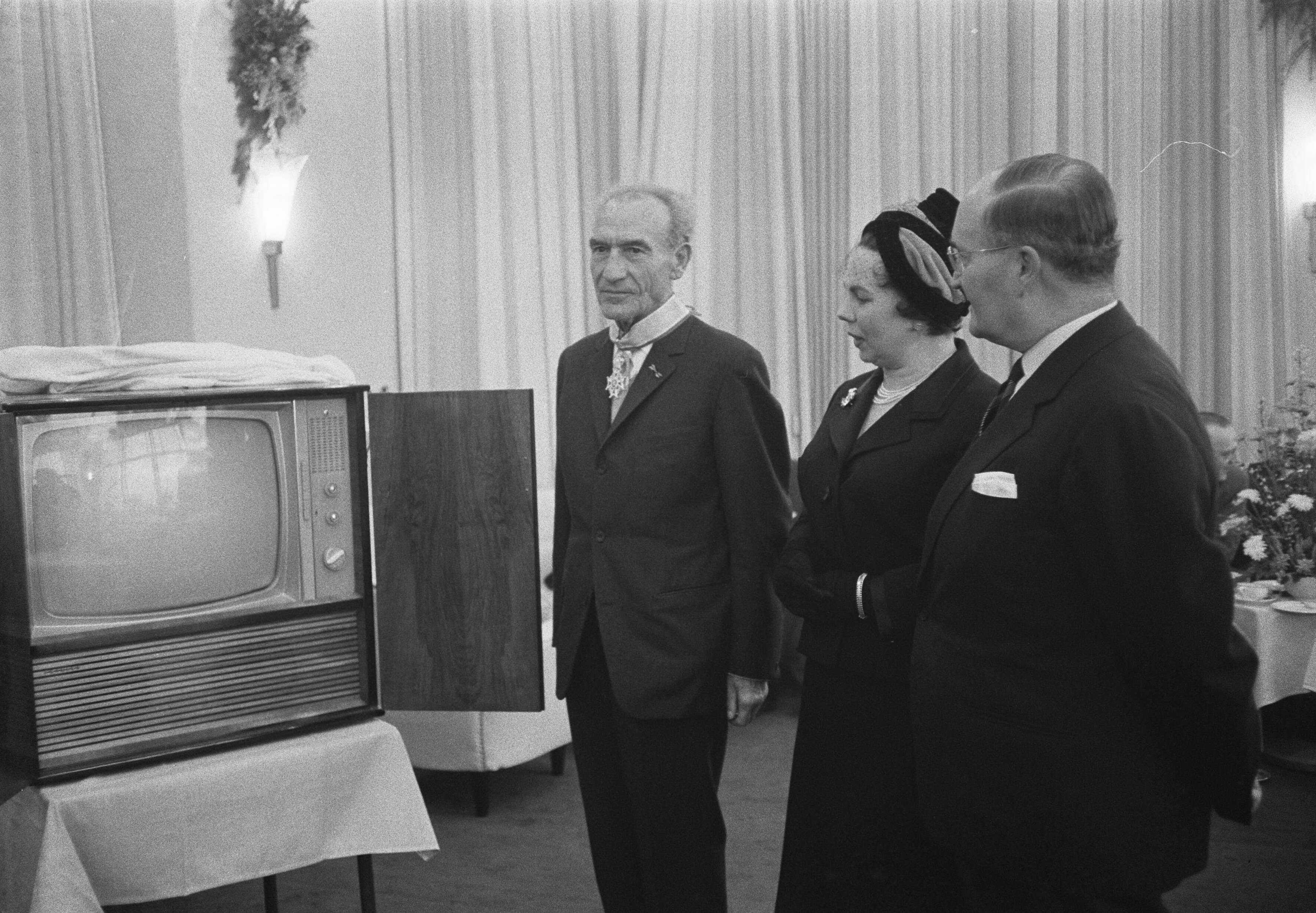 Fotocollectie Anefo — Afscheidsreceptie van de voorzitter van het College van Rijksbemiddelaars mr. J.A. Berger, mr. Berger en zijn echtgenote, Marie Regina Berger-Reyne, bij een cadeau, een televisiemeubel — Foto: Pot, Harry / Anefo. Licentie: Set B: Rechtenvrij / Publiek Domein. Bron: Nationaal Archief. http://hdl.handle.net/10648/a9c3f648-d0b4-102d-bcf8-003048976d84