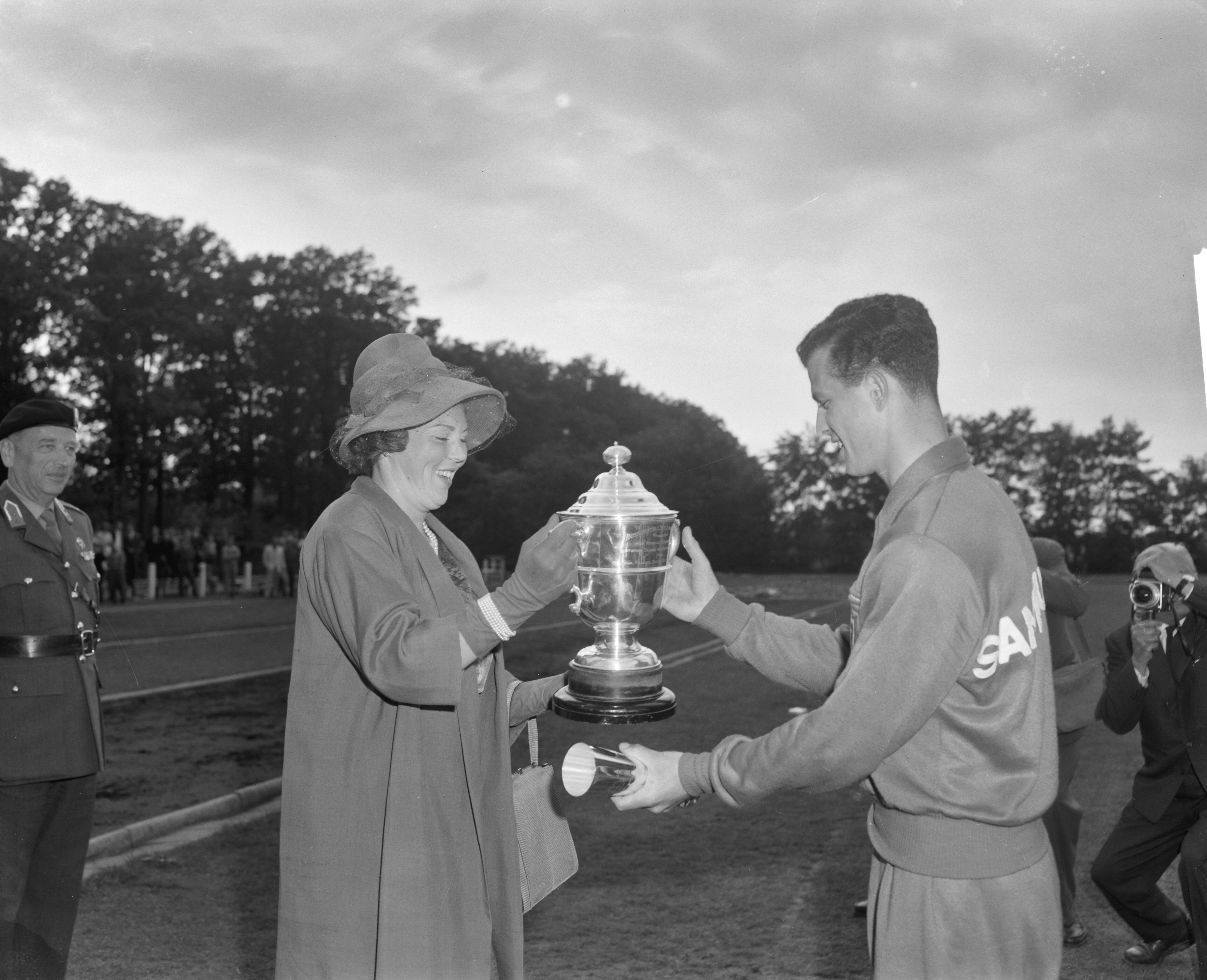 Fotocollectie Anefo — West-Europese kadetten-atletiekwedstrijden in Breda. Prinses Beatrix reikt, in plaats van prins Bernhard, een beker uit — Foto: Bilsen, Joop van / Anefo. Licentie: Set B: Rechtenvrij / Publiek Domein. Bron: Nationaal Archief. http://hdl.handle.net/10648/aa0caece-d0b4-102d-bcf8-003048976d84