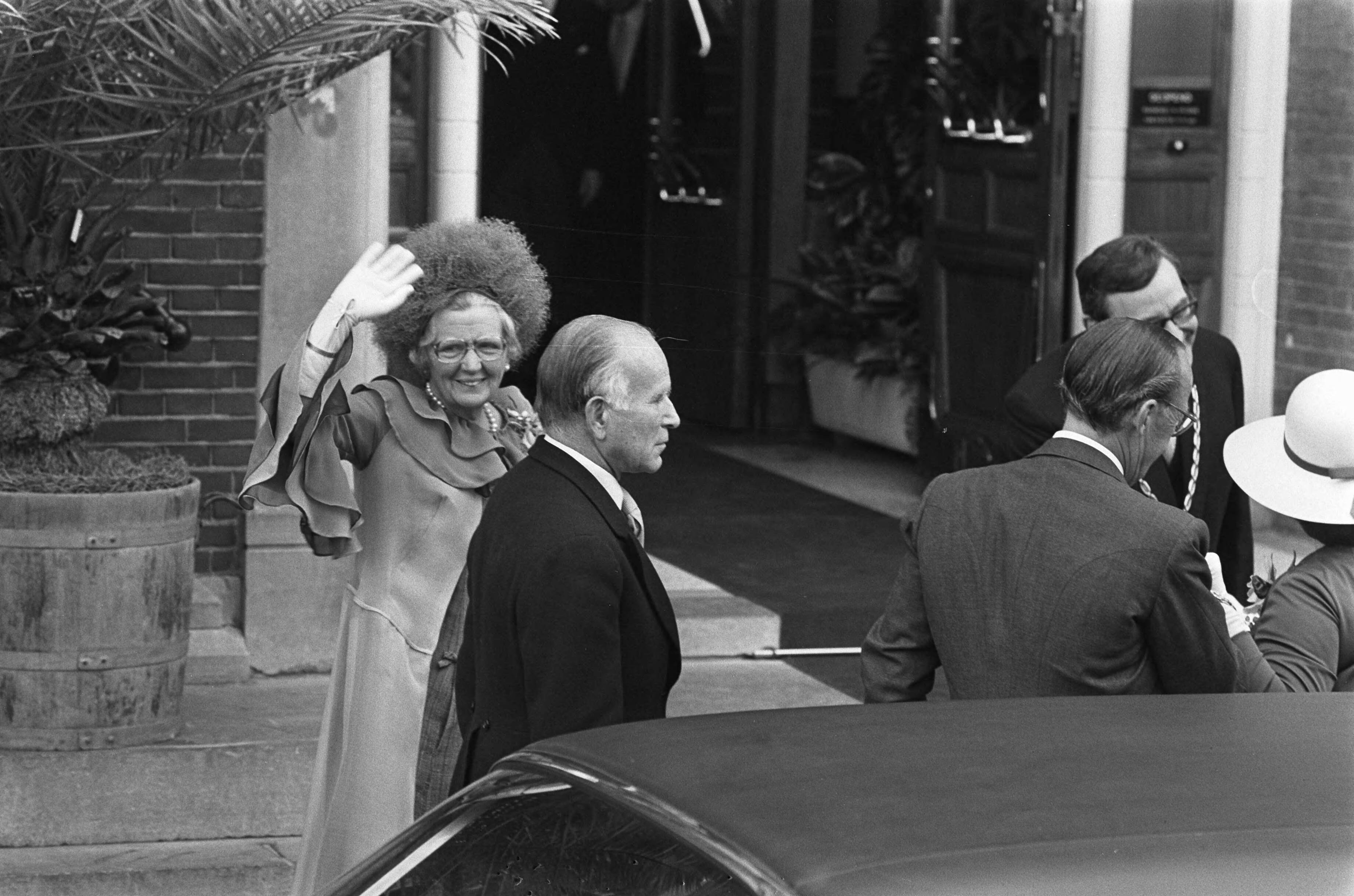 Huwelijk prinses Christina en Jorge Guillermo; de sluiting van het burgerlijk huwelijk in het stadhuis van Baarn — Koningin Juliana zwaaiend bij het stadhuis — Foto: Meerdere fotografen / Anefo. Licentie: Set B: Rechtenvrij / Publiek Domein. Bron: Nationaal Archief. http://hdl.handle.net/10648/ac6c552a-d0b4-102d-bcf8-003048976d84