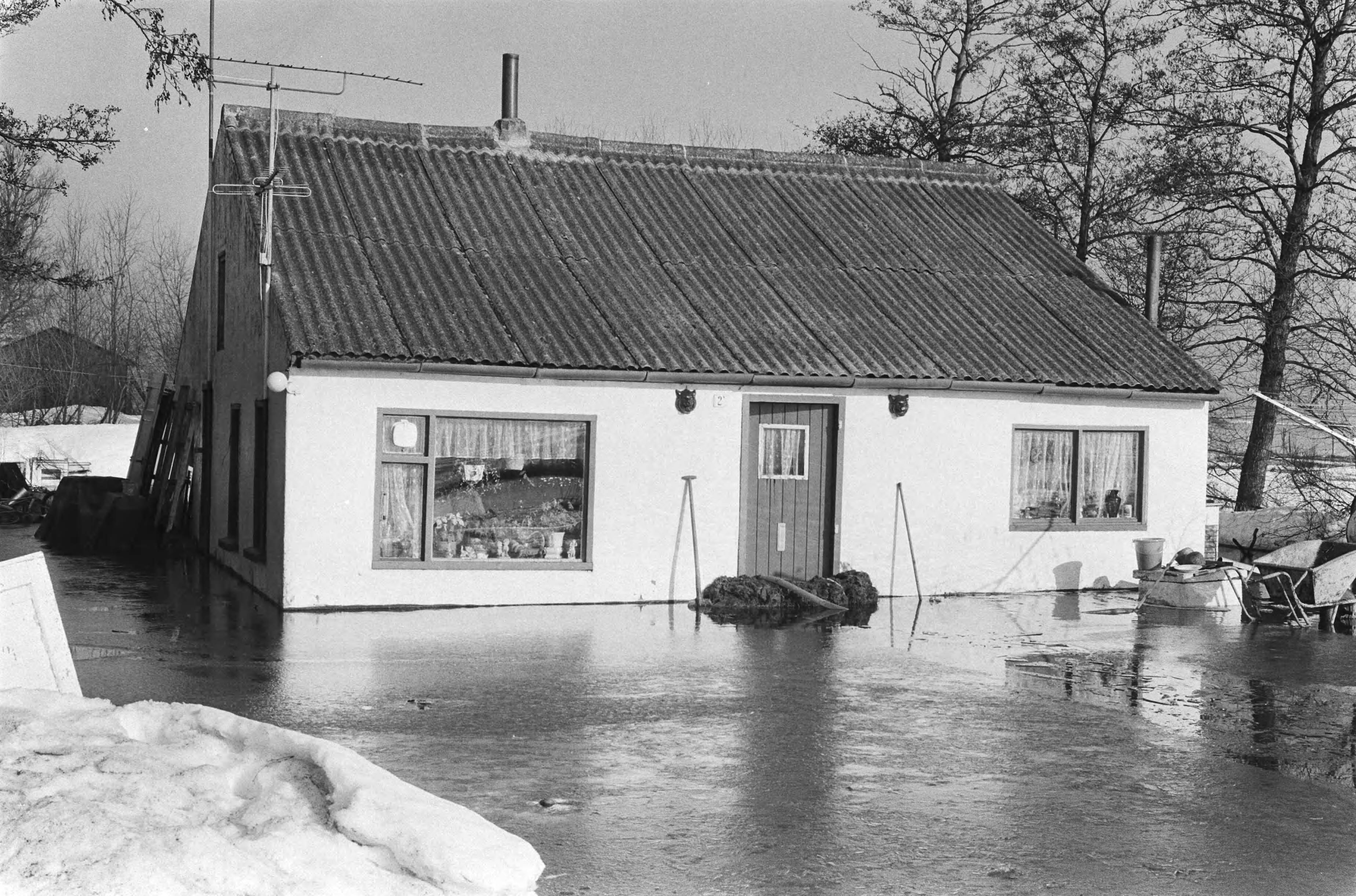 Wateroverlast in Groningen en Friesland — Woning omgeven door water — Foto: Suyk, Koen / Anefo. Licentie: Set B: Rechtenvrij / Publiek Domein. Bron: Nationaal Archief. http://hdl.handle.net/10648/acc5a17a-d0b4-102d-bcf8-003048976d84