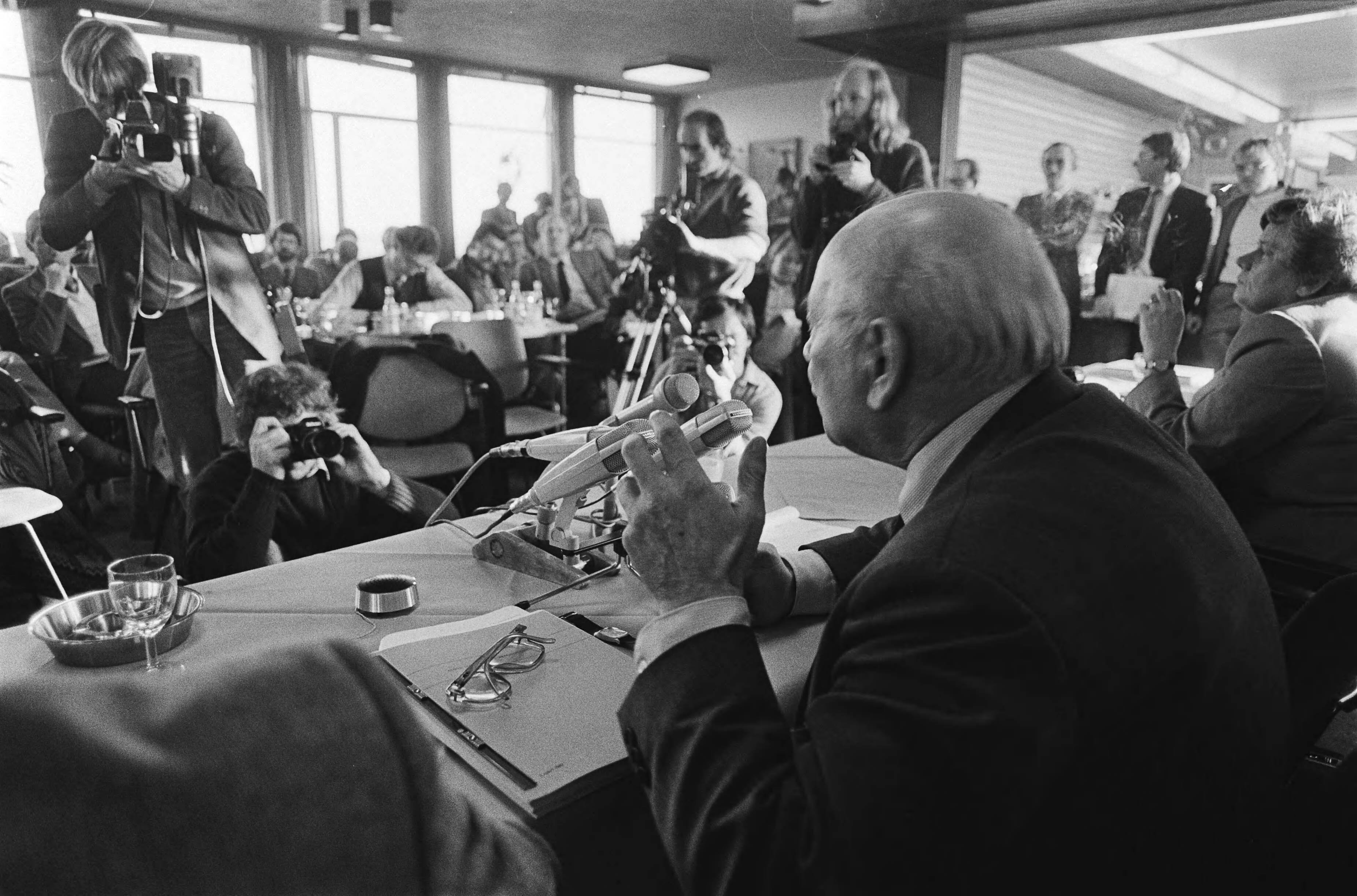 Fotocollectie Anefo — Den Uyl presenteert het werkgelegenheidsprogramma in eerste aanleg tijdens pc in Den Haag . Den Uyl tijdens de pc met veel pers tegenover hem / — Foto: Antonisse, Marcel / Anefo. Licentie: Set B: Rechtenvrij / Publiek Domein. Bron: Nationaal Archief. http://hdl.handle.net/10648/ad118f2c-d0b4-102d-bcf8-003048976d84