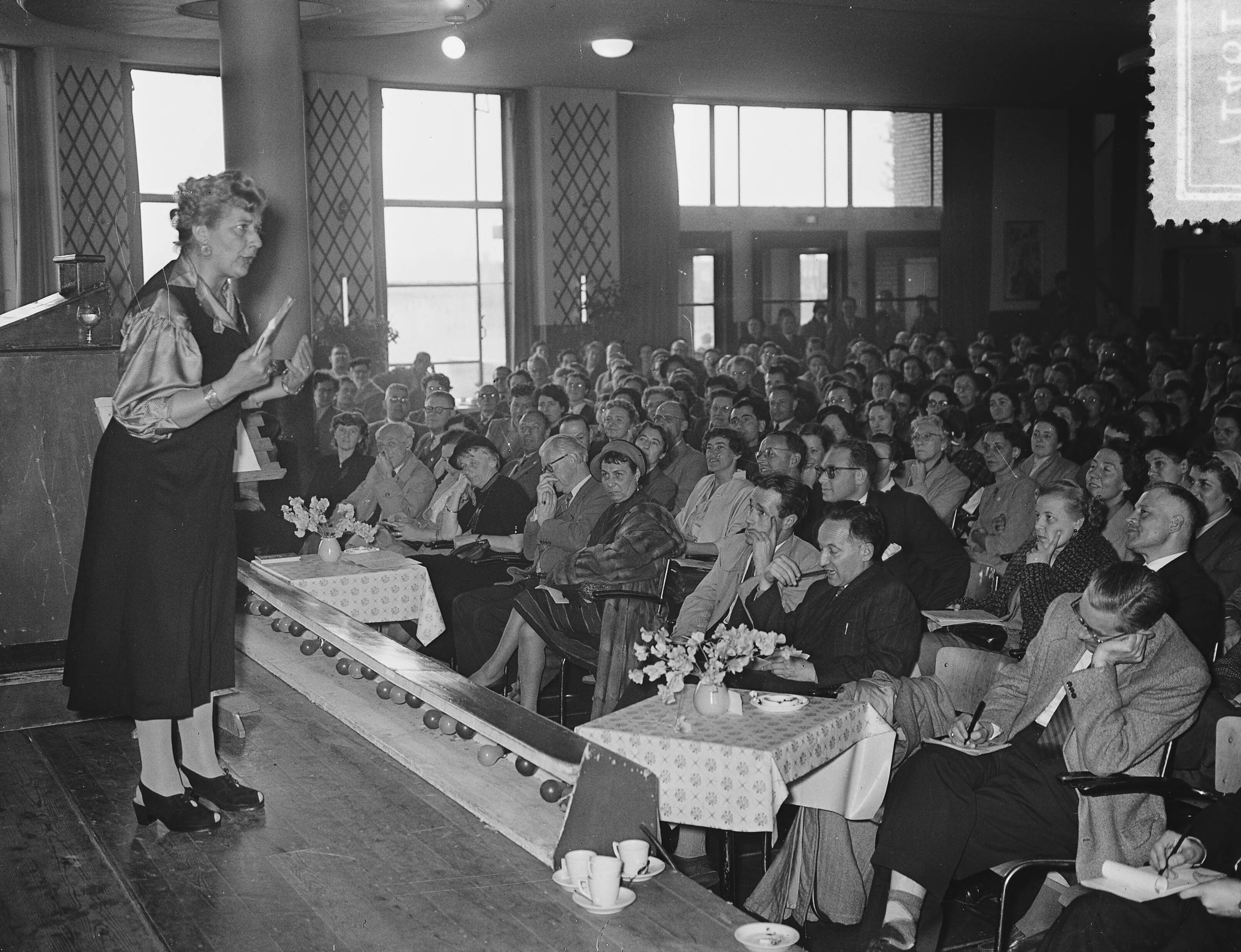 Fotocollectie Anefo — Wereld Vrijgezellendag in de Houtrusthallen te Den Haag. Mary Pos bracht een speciale boodschap uit Amerika — Foto: Bilsen, Joop van / Anefo. Licentie: Set B: Rechtenvrij / Publiek Domein. Bron: Nationaal Archief. http://hdl.handle.net/10648/a9358fc0-d0b4-102d-bcf8-003048976d84