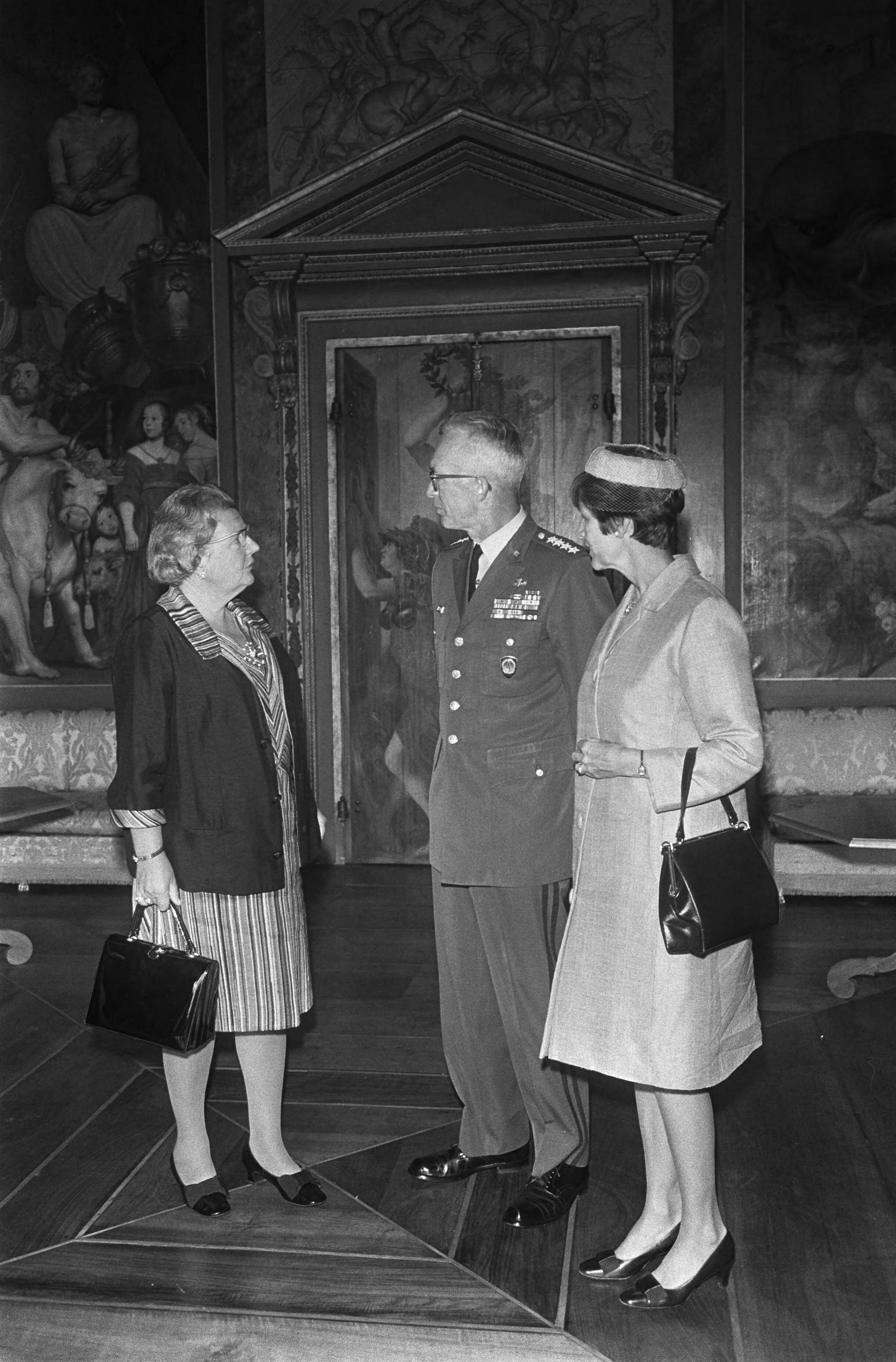 Koningin Juliana ontvangt Generaal Goodpaster en diens echtgenote op Huis ten Bosch, Den Haag — Koningin Juliana, generaal Andrew J. Goodpaster en mevrouw Goodpaster — Foto: Fotograaf Onbekend / Anefo. Licentie: Set B: Rechtenvrij / Publiek Domein. Bron: Nationaal Archief. http://hdl.handle.net/10648/ab78d5f8-d0b4-102d-bcf8-003048976d84