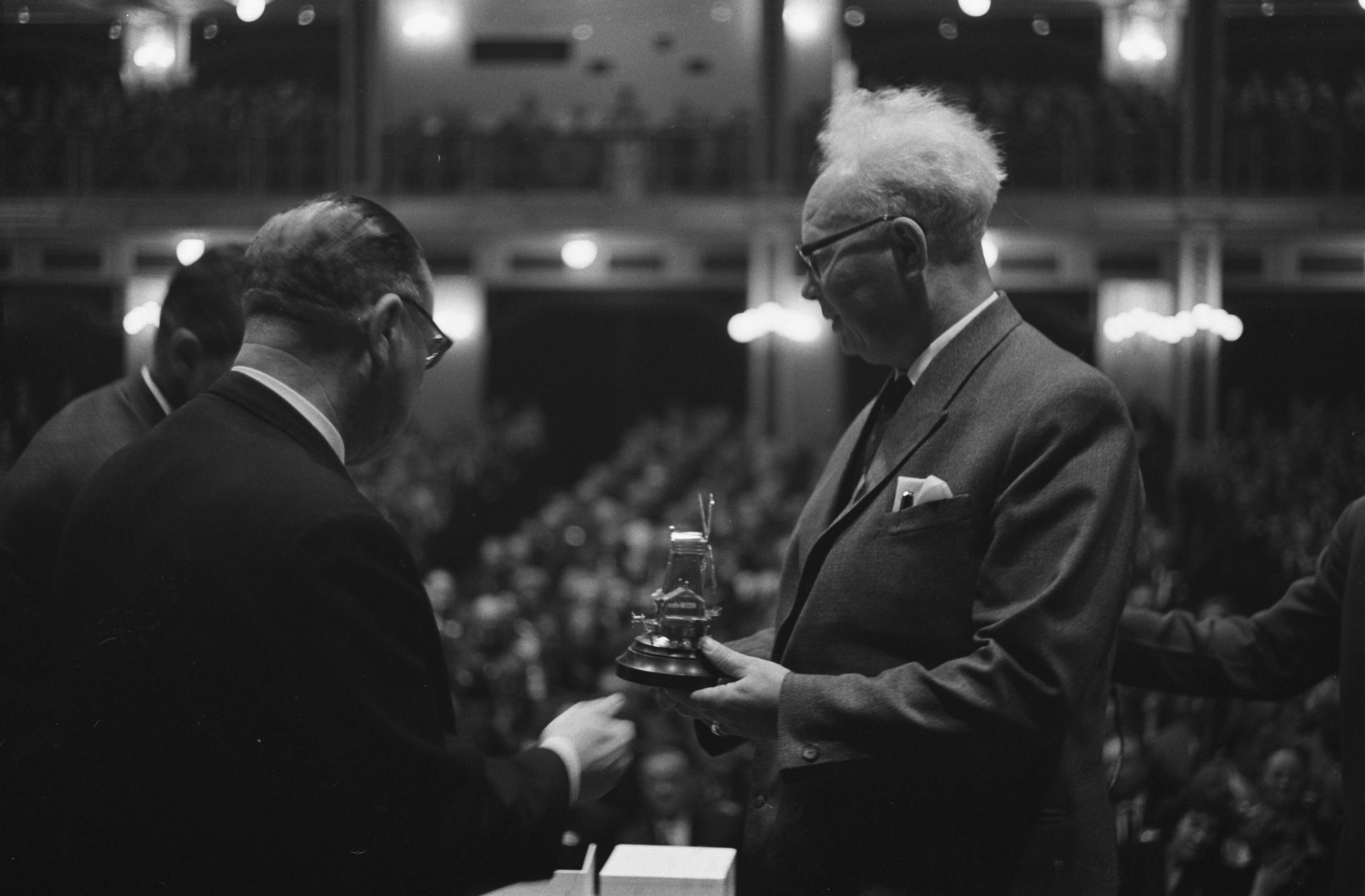 Fotocollectie Anefo — Houtdag 1962, in het Kurhaus, de zilveren houtzaagmolen uitgereikt aan de heer A. Rauwerda, onderwijsexpert op het terrein van de machinale houtbewerking. Hij ontvangt de onderscheiding uit handen van ir. G.H.J.M Moerkerk, inspecteur van het nijverheidsonderwijs in Den Haag — Foto: Pot, Harry / Anefo. Licentie: Set B: Rechtenvrij / Publiek Domein. Bron: Nationaal Archief. http://hdl.handle.net/10648/aa1c14d6-d0b4-102d-bcf8-003048976d84