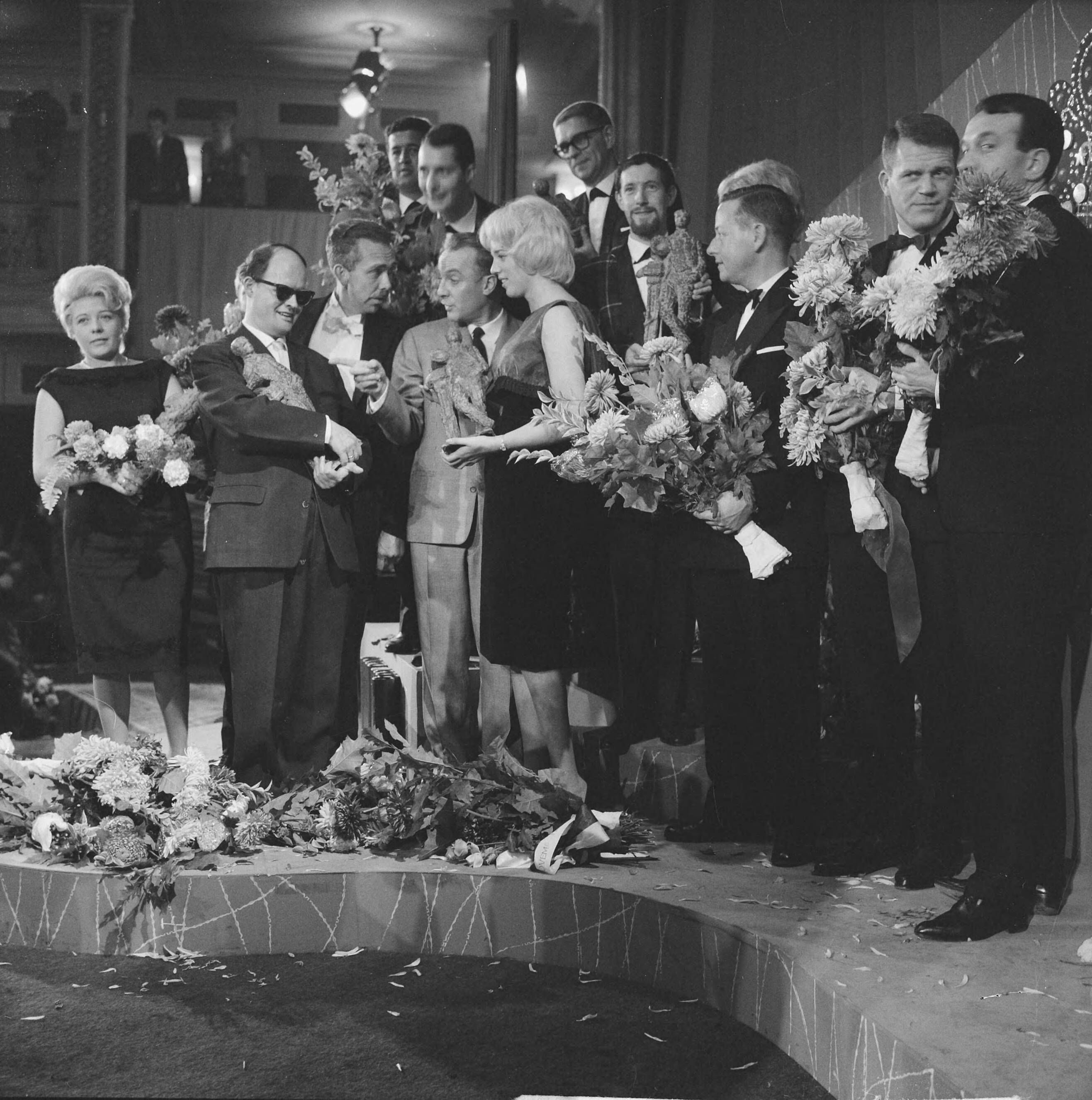 Grand Gala du Disque 1962 — Grand Gala du Disque. UItreiking Edisons. Vlnr. Thérèse Michielsen (mevr. Brel),, Jules de Corte, Jean Dulieu,,Wim Sonneveld, Ellen Craamer, [leden Diamond Five], Cees Slinger (met bril), Jean Dulieu, [leden Ad van den Hoed Combo] — Foto: Koch, Eric / Anefo. Licentie: Set B: Rechtenvrij / Publiek Domein. Bron: Nationaal Archief. http://hdl.handle.net/10648/aa195bec-d0b4-102d-bcf8-003048976d84
