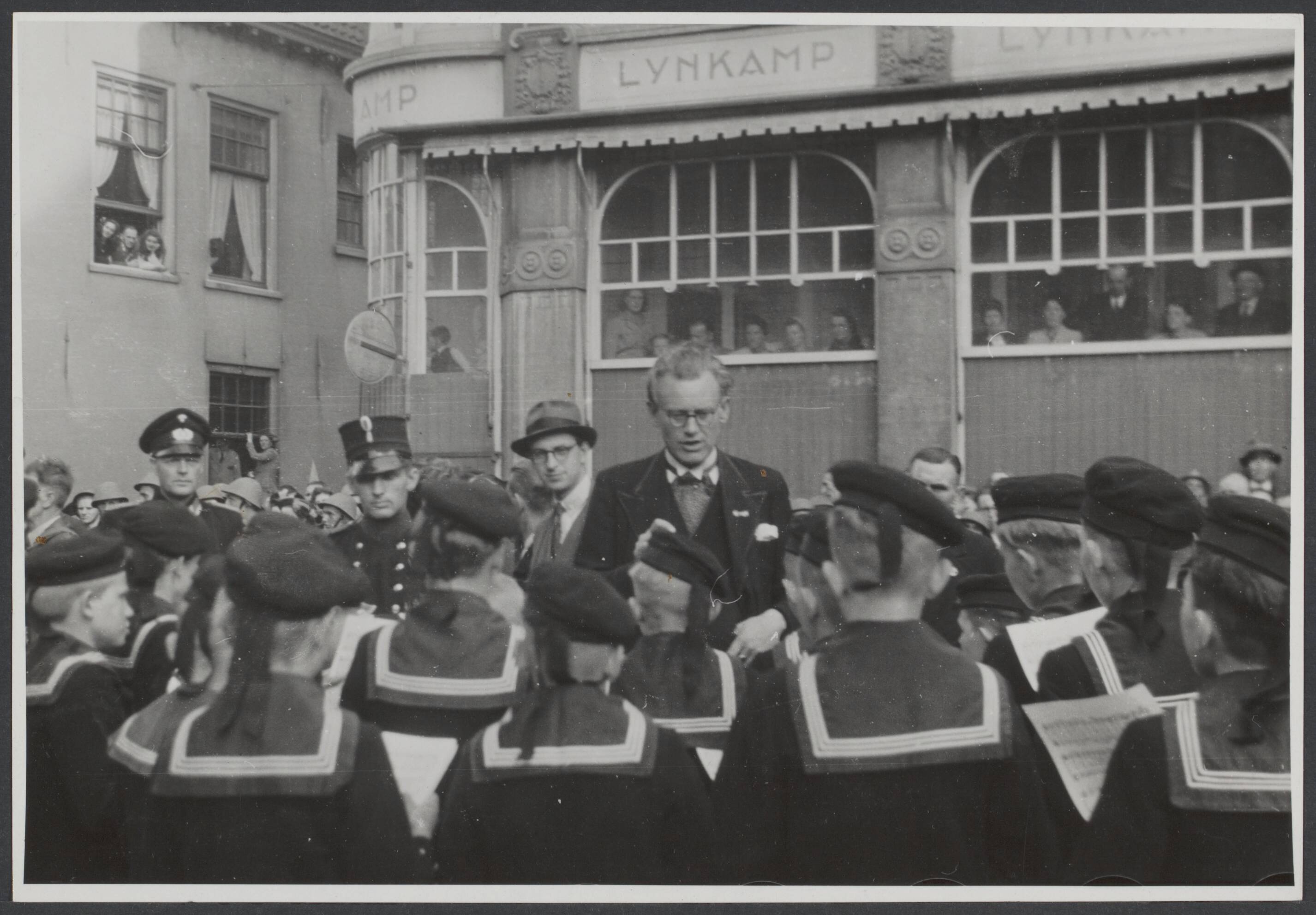 Bevrijding 's Gravenhage (Den Haag) — Het matrozenkoor maakt zich gereed om te zingen, tijdens de intocht der Canadezen te Den Haag — Foto: Wal, J.Th. A. van der / Spaarnestad. Licentie: Set B: Rechtenvrij / Publiek Domein. Bron: Nationaal Archief. http://hdl.handle.net/10648/be7a354f-1319-59ba-1e2f-0257f333ba25