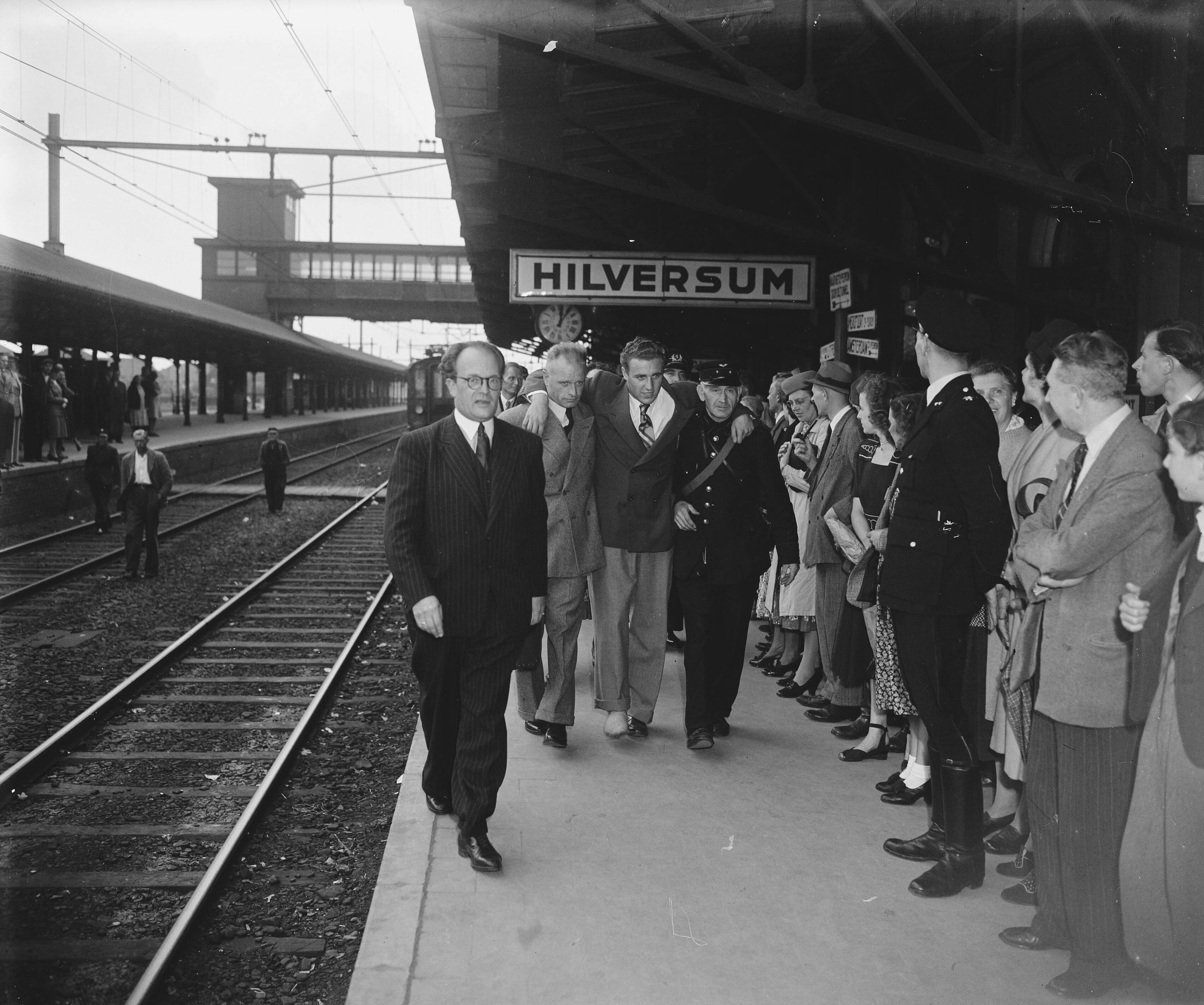 Fotocollectie Anefo — Nel Van Vliet gehuldigd in Hilversum. De geblesseerde waterpolospeler Rohner bij aankomst op station Hilversum — Foto: Snikkers, Anton / Anefo. Licentie: Set B: Rechtenvrij / Publiek Domein. Bron: Nationaal Archief. http://hdl.handle.net/10648/a8bb1e3e-d0b4-102d-bcf8-003048976d84