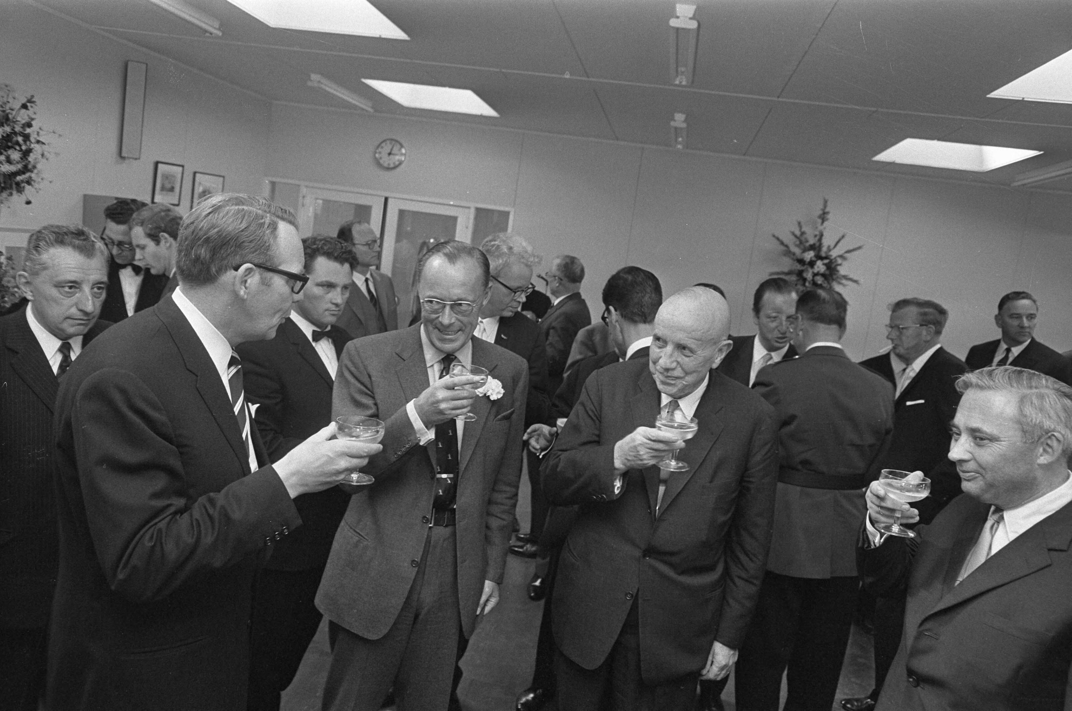 Prins Bernhard bezoekt Zeeland — Er wordt een glaasje gedronken — Foto: Fotograaf Onbekend / Anefo. Licentie: Set B: Rechtenvrij / Publiek Domein. Bron: Nationaal Archief. http://hdl.handle.net/10648/ab4d68e6-d0b4-102d-bcf8-003048976d84