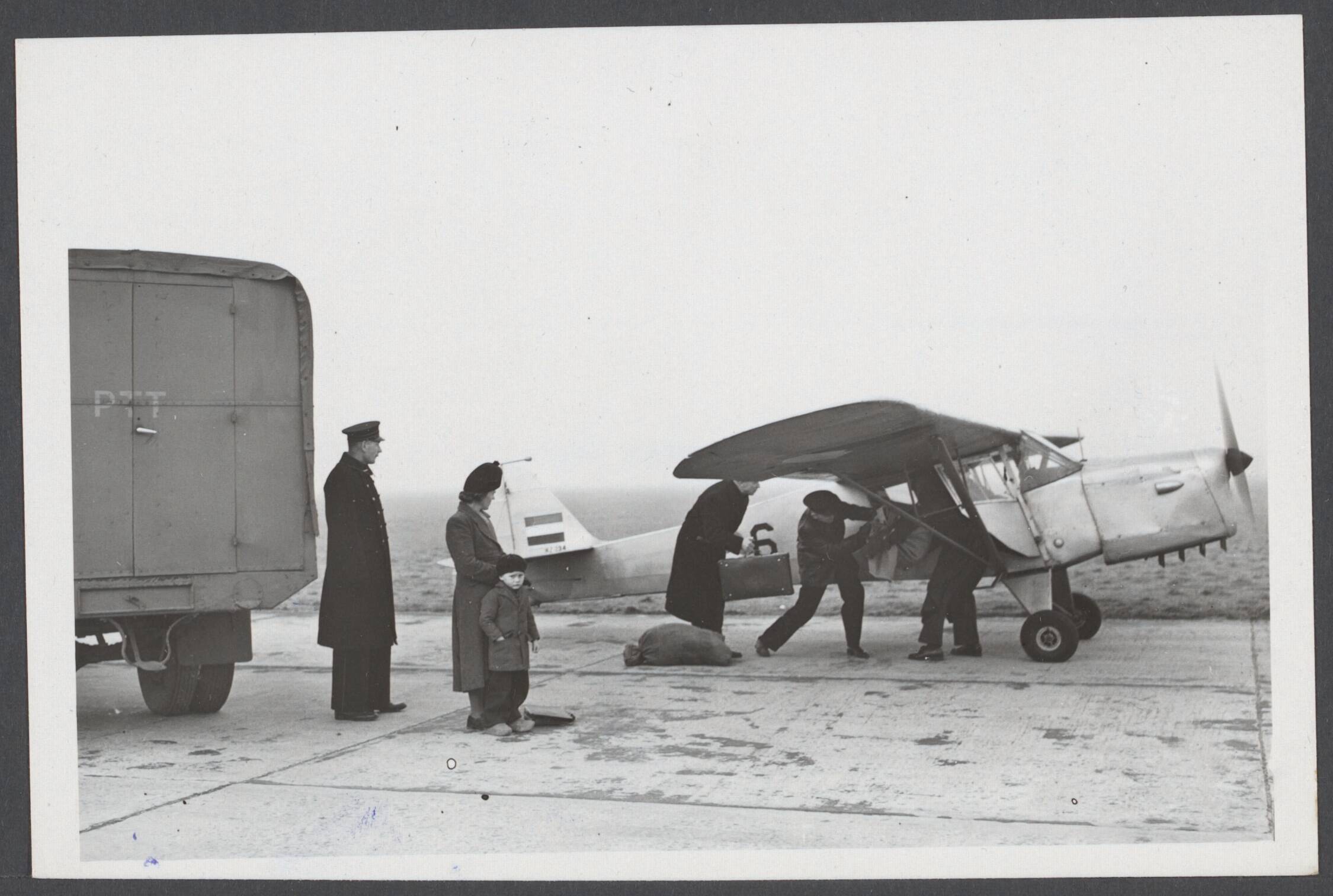 Vliegvelden - Nederland, Beek t/m Waalhaven — Per Auster van Leeuwarden naar Ameland, dat niet meer per boot bereikbaar is. De post wordt op het vliegveld Leeuwarden ingeladen, terwijl mevrouw Brouwer met zoontje na onderzoek in het ziekenhuis eveneens met het vliegtuig terug naar Ameland gaat — Foto: Fotograaf Onbekend / Anefo. Licentie: Set B: Rechtenvrij / Publiek Domein. Bron: Nationaal Archief. http://hdl.handle.net/10648/898f49cb-aadd-2e49-a6c1-823a51f32cc0